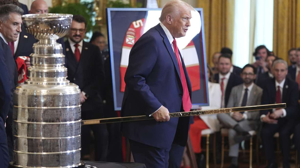 President Donald Trump holds a gold hockey stick present to him by the the 2024 NHL Stanley Cup champion Florida Panthers hockey team during a ceremony in the East Room of the White House, Monday, Feb. 3, 2025, in Washington.