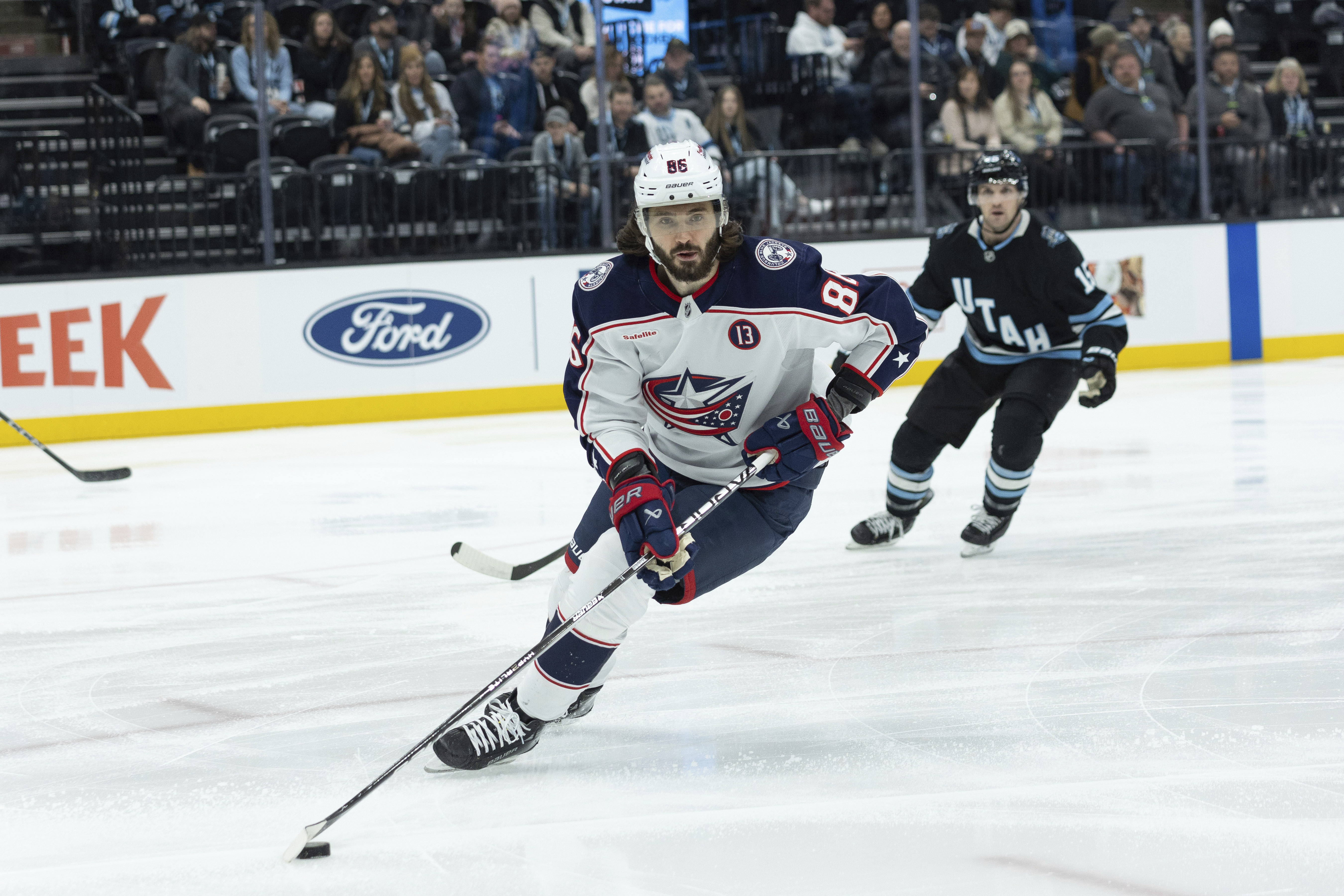 Columbus Blue Jackets right wing Kirill Marchenko (86) skates with the puck against Utah Hockey Club center Alexander Kerfoot (15) during the first period of an NHL hockey game Friday, Jan. 31, 2025, in Salt Lake City. 