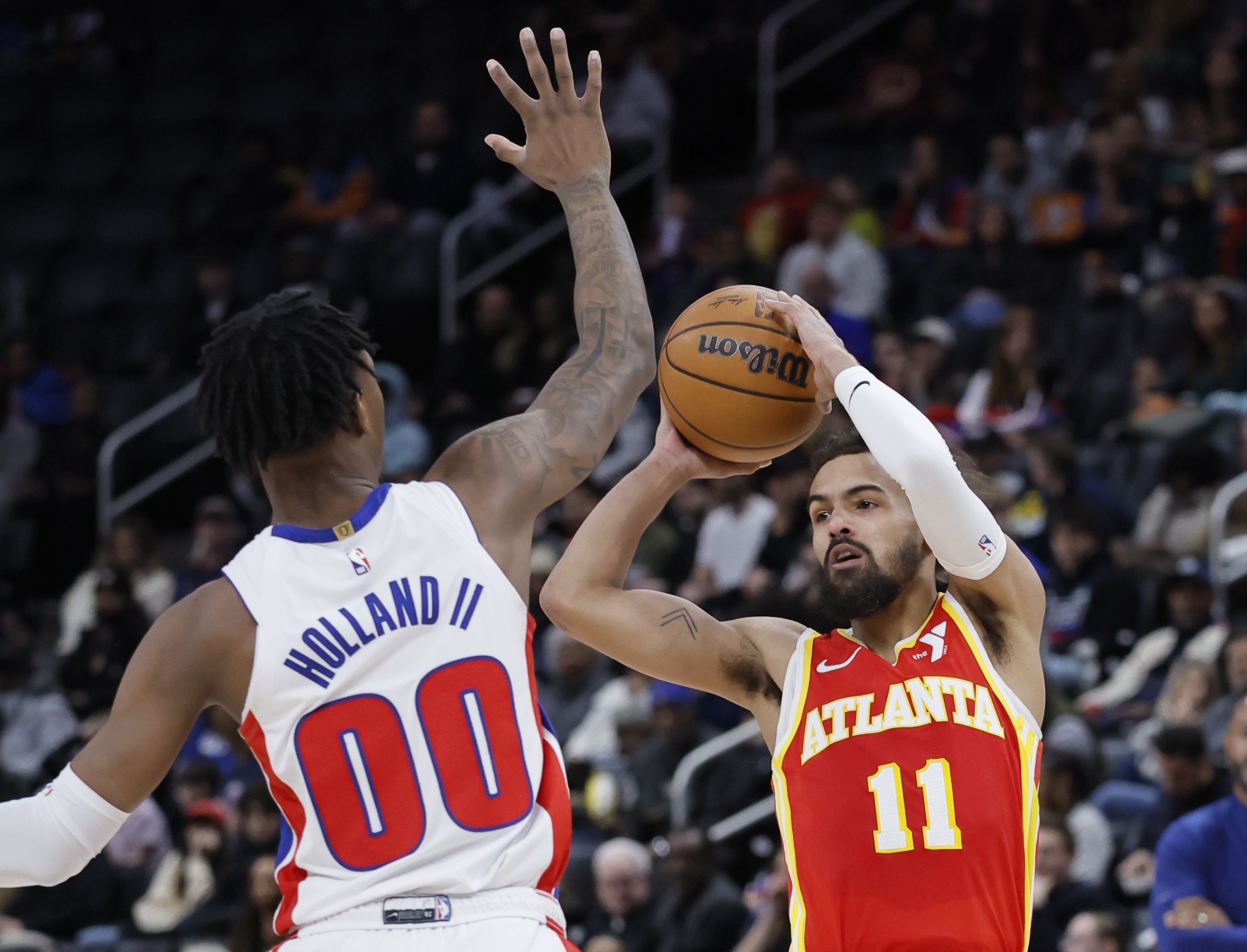 Atlanta Hawks guard Trae Young (11) looks to pass the ball against Detroit Pistons forward Ronald Holland II (00) during the first half of an NBA basketball game Monday, Feb. 3, 2025, in Detroit. 