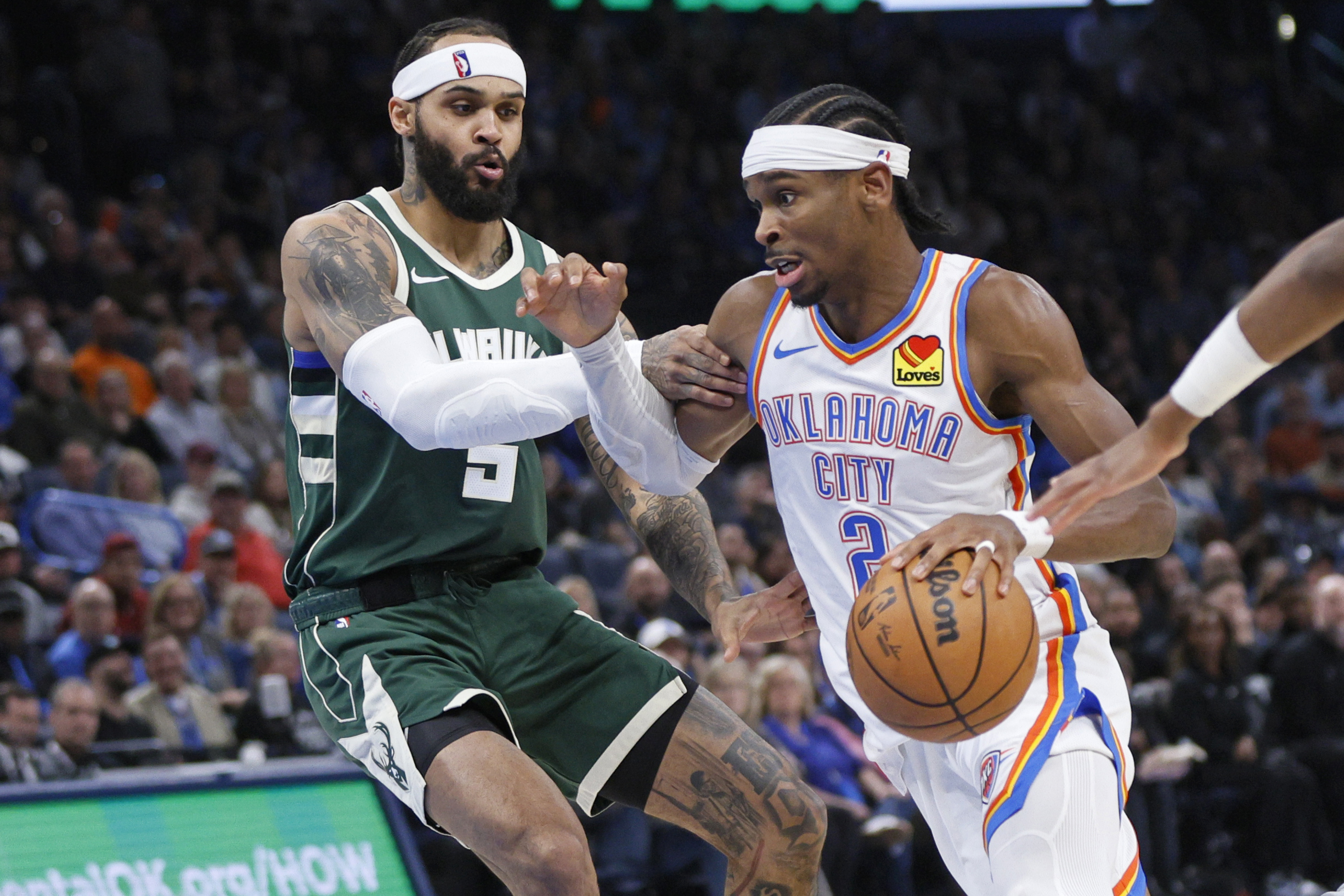 Oklahoma City Thunder guard Shai Gilgeous-Alexander, right, drives against Milwaukee Bucks guard Gary Trent Jr., left, during the second half of an NBA basketball game Monday, Feb. 3, 2025, in Oklahoma City. 