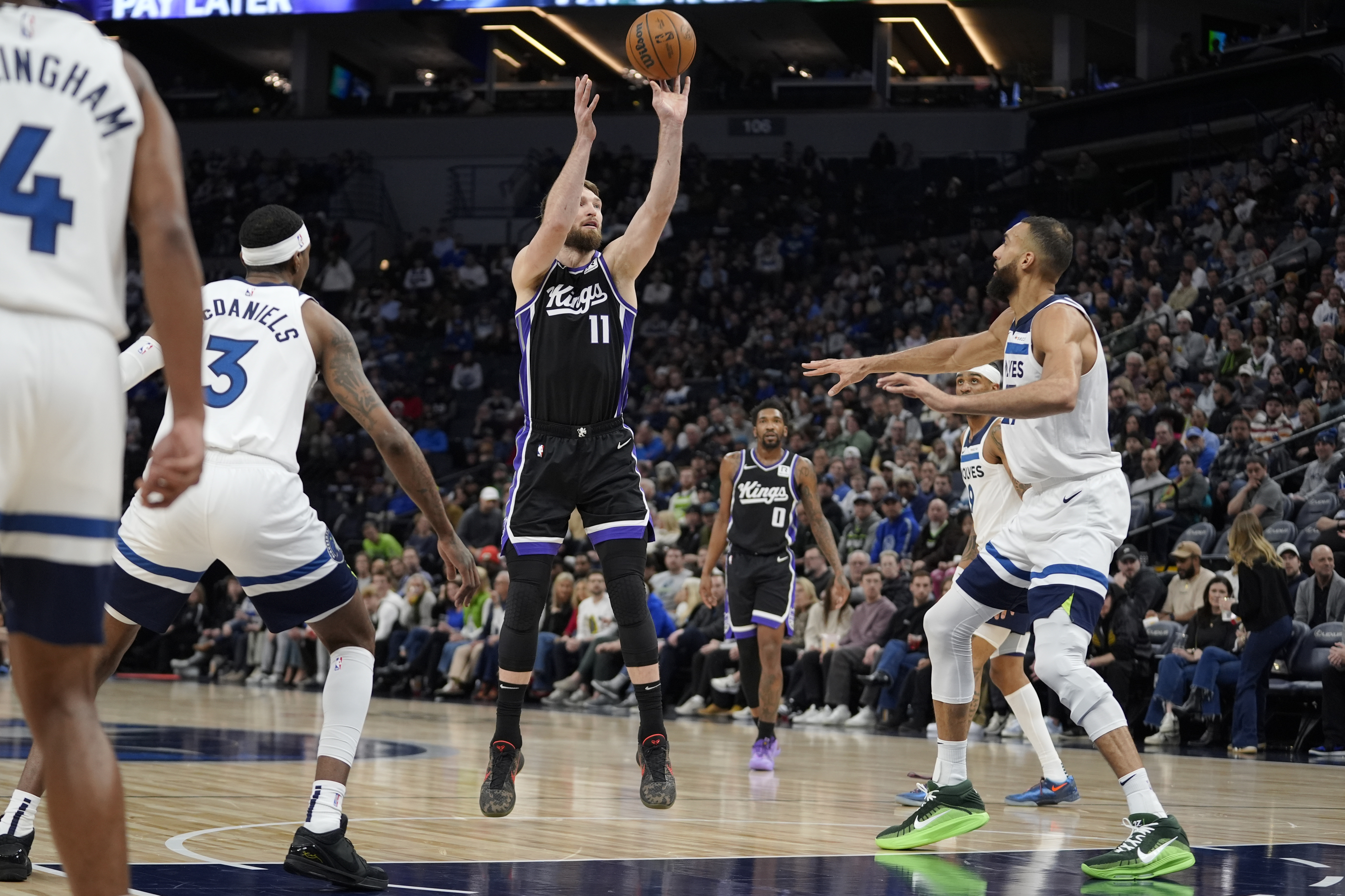 Sacramento Kings forward Domantas Sabonis (11) shoots over Minnesota Timberwolves center Rudy Gobert (27), right, during the first half of an NBA basketball game, Monday, Feb. 3, 2025, in Minneapolis. 
