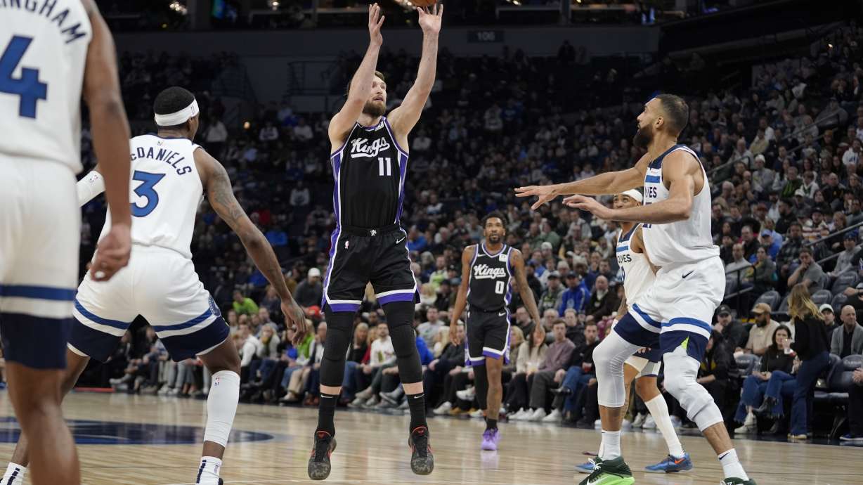 Sacramento Kings forward Domantas Sabonis (11) shoots over Minnesota Timberwolves center Rudy Gobert (27), right, during the first half of an NBA basketball game, Monday, Feb. 3, 2025, in Minneapolis.