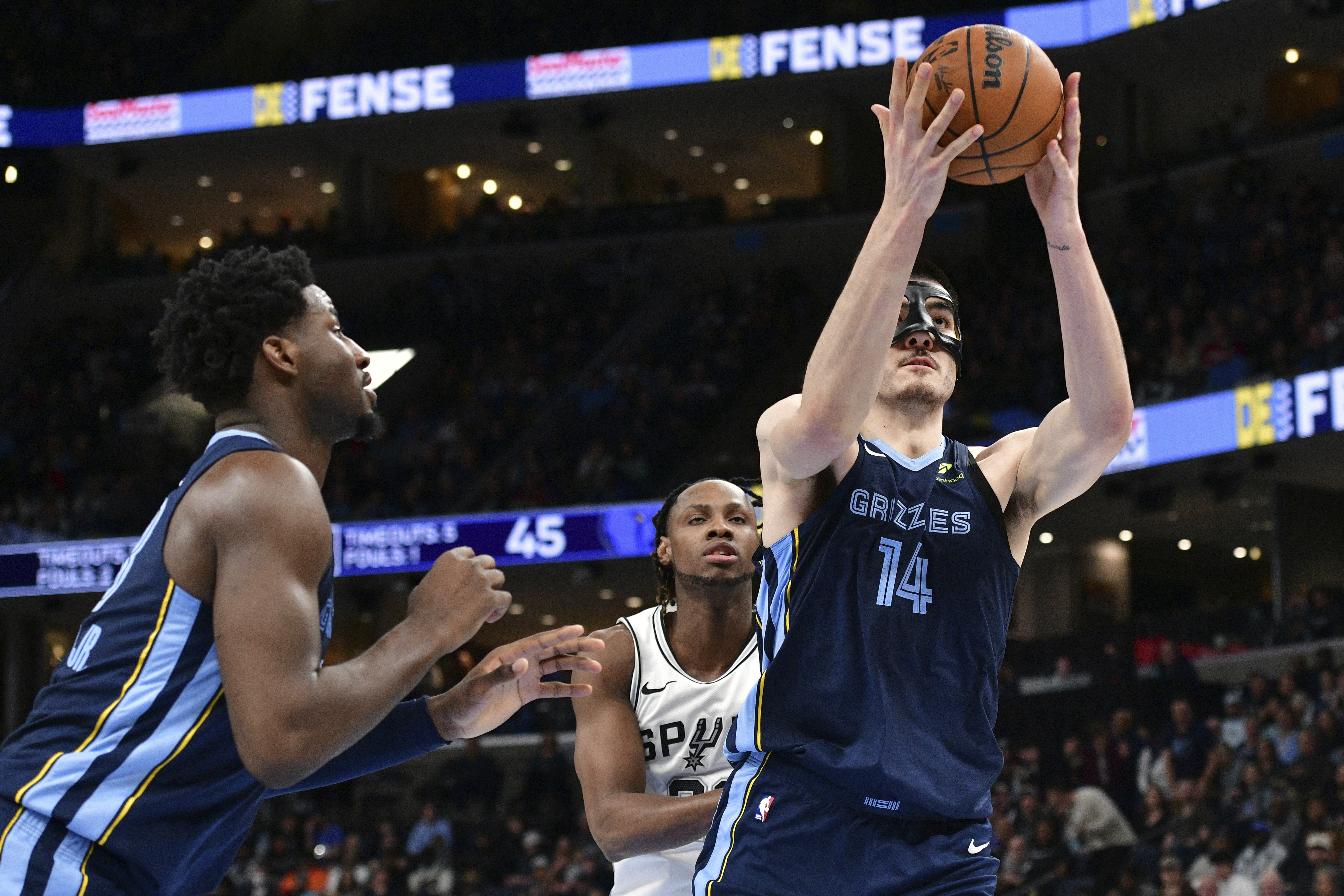 Memphis Grizzlies center Zach Edey (14) handles the ball ahead of San Antonio Spurs center Charles Bassey, center, and forward Jaren Jackson Jr., left, in the first half of an NBA basketball game Monday, Feb. 3, 2025, in Memphis, Tenn. 