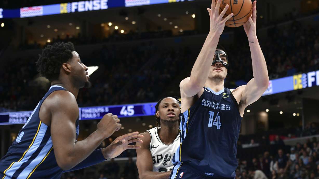 Memphis Grizzlies center Zach Edey (14) handles the ball ahead of San Antonio Spurs center Charles Bassey, center, and forward Jaren Jackson Jr., left, in the first half of an NBA basketball game Monday, Feb. 3, 2025, in Memphis, Tenn.
