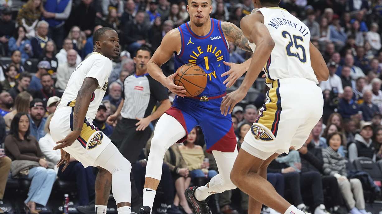 Denver Nuggets forward Michael Porter Jr., center, drives to the basket as New Orleans Pelicans guards Javonte Green, left, and Trey Murphy III, right, defend in the first half of an NBA basketball game Monday, Feb. 3, 2025, in Denver.