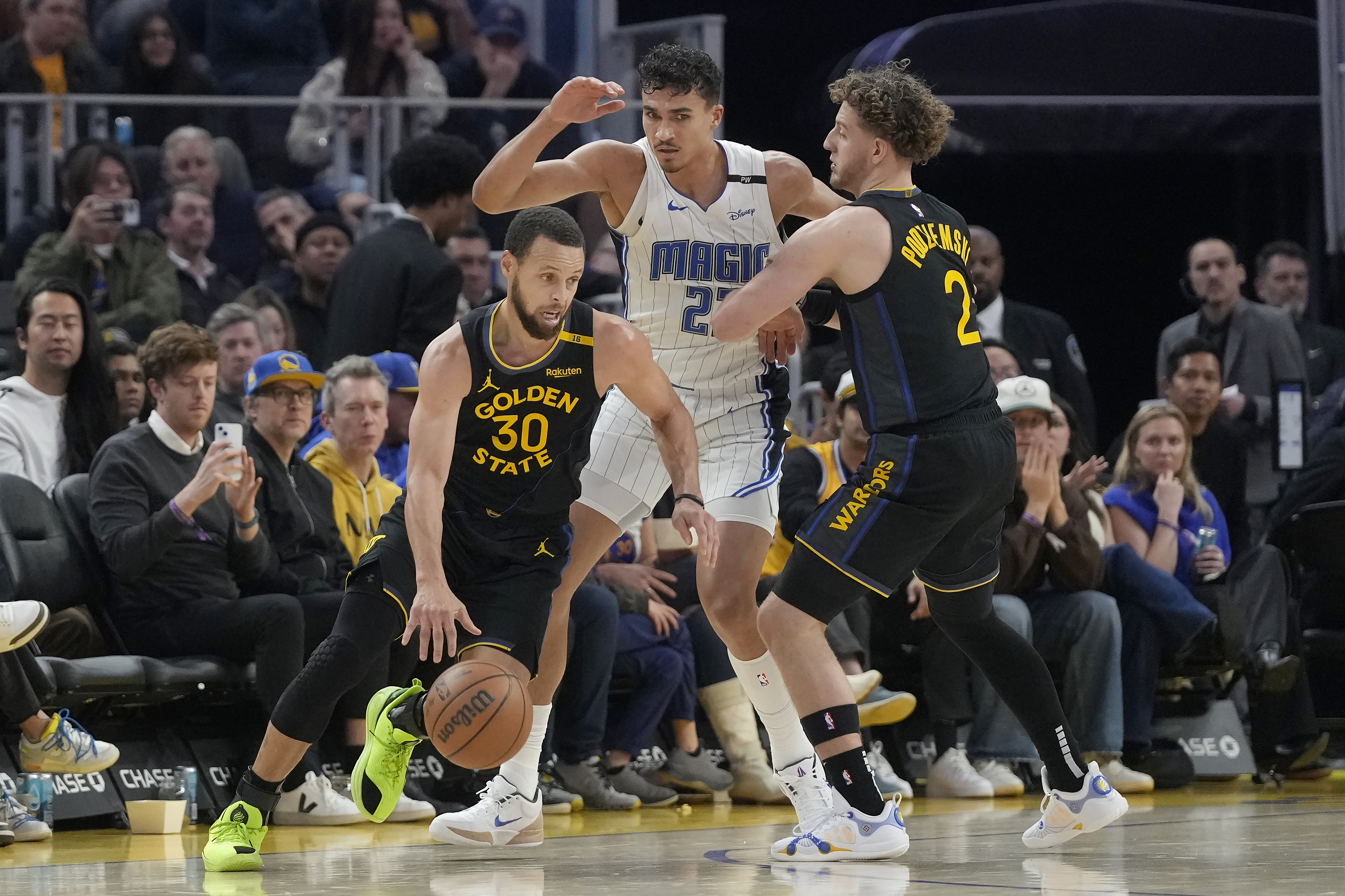 Golden State Warriors guard Stephen Curry (30) drives to the basket as guard Brandin Podziemski (2) screens Orlando Magic forward Tristan da Silva, middle, during the first half of an NBA basketball game in San Francisco, Monday, Feb. 3, 2025. 