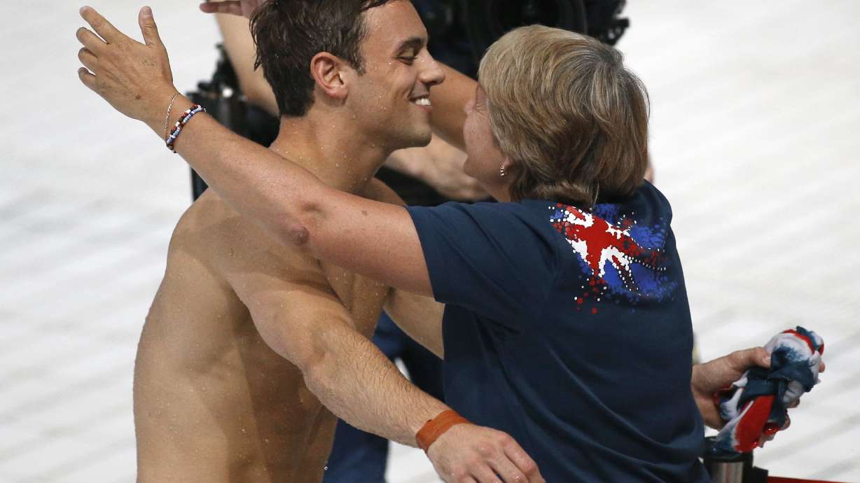 FILE - Britain's bronze medalist Thomas Daley celebrates his victory with coach Jane Figueiredo after the men's 10m platform diving final at the Swimming World Championships in Kazan, Russia, Sunday, Aug. 2 2015.