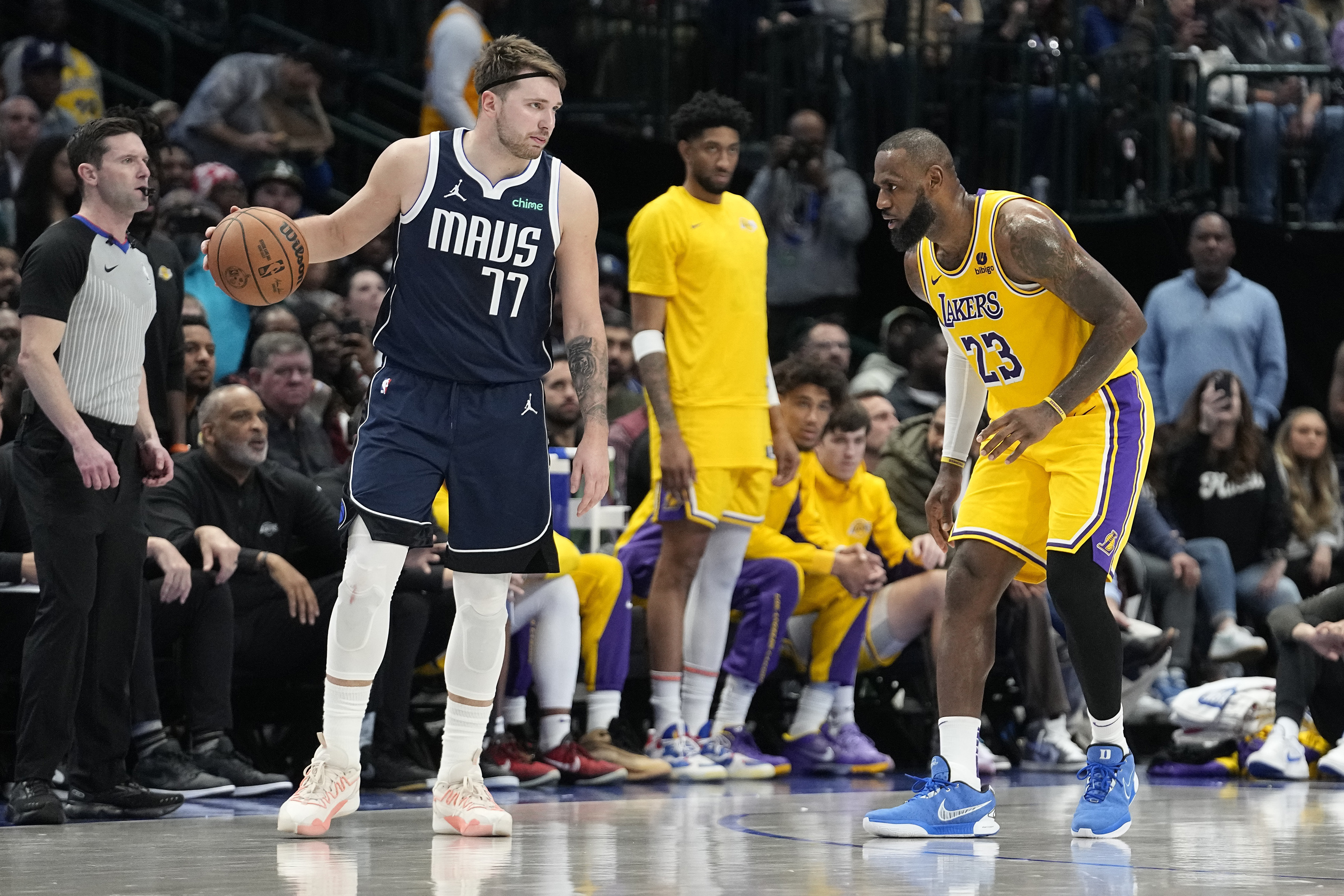 FILE - Dallas Mavericks guard Luka Doncic (77) dribbles against Los Angeles Lakers forward LeBron James (23) during the second half of an NBA basketball game in Dallas, Dec. 12, 2023.