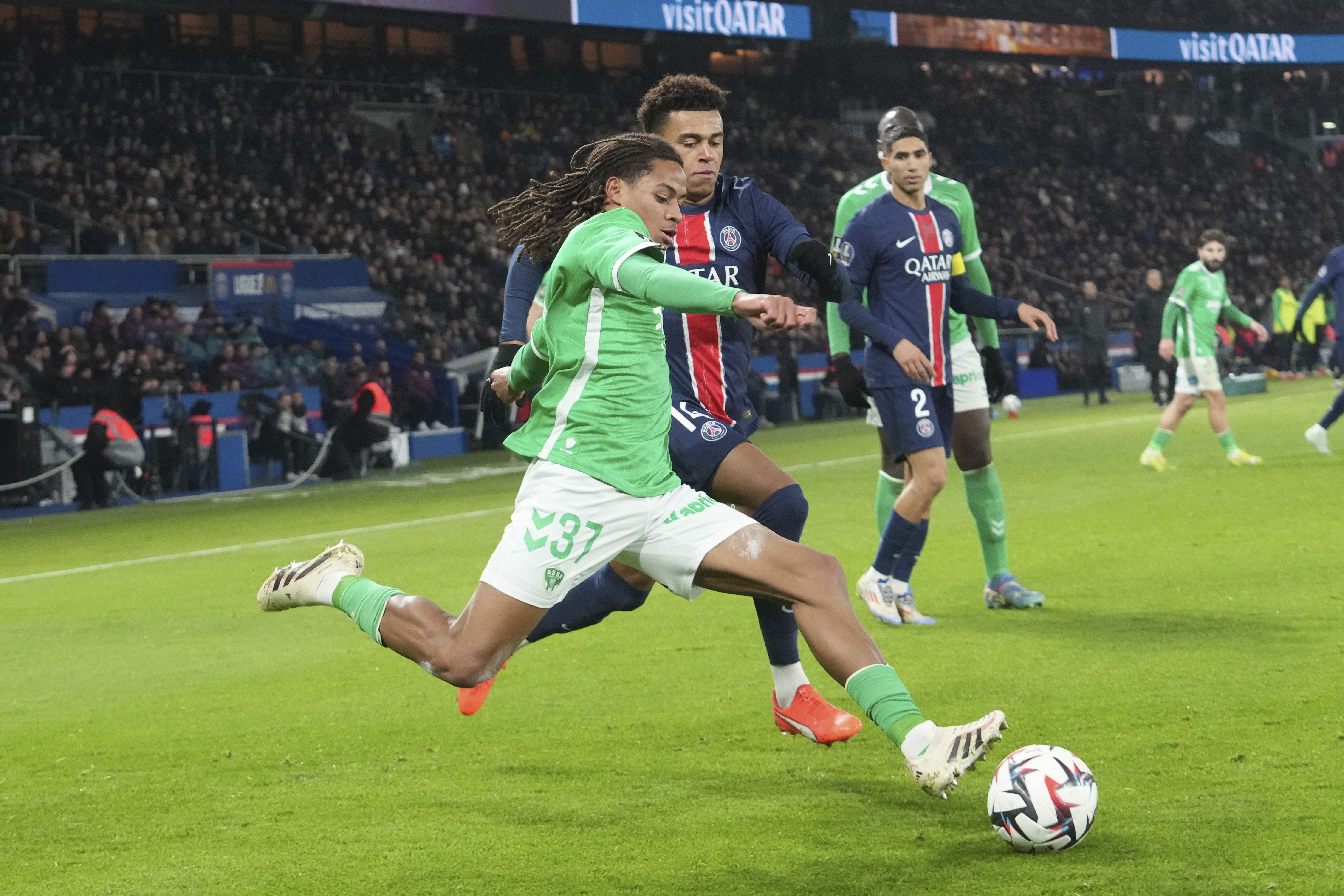 Saint-Etienne's Mathis Amougou, left, and PSG's Desire Doue challenge for the ball during the French League One soccer match between Paris Saint-Germain and Saint-Etienne at the Parc des Princes stadium in Paris, France, Sunday, Jan. 12, 2025. 