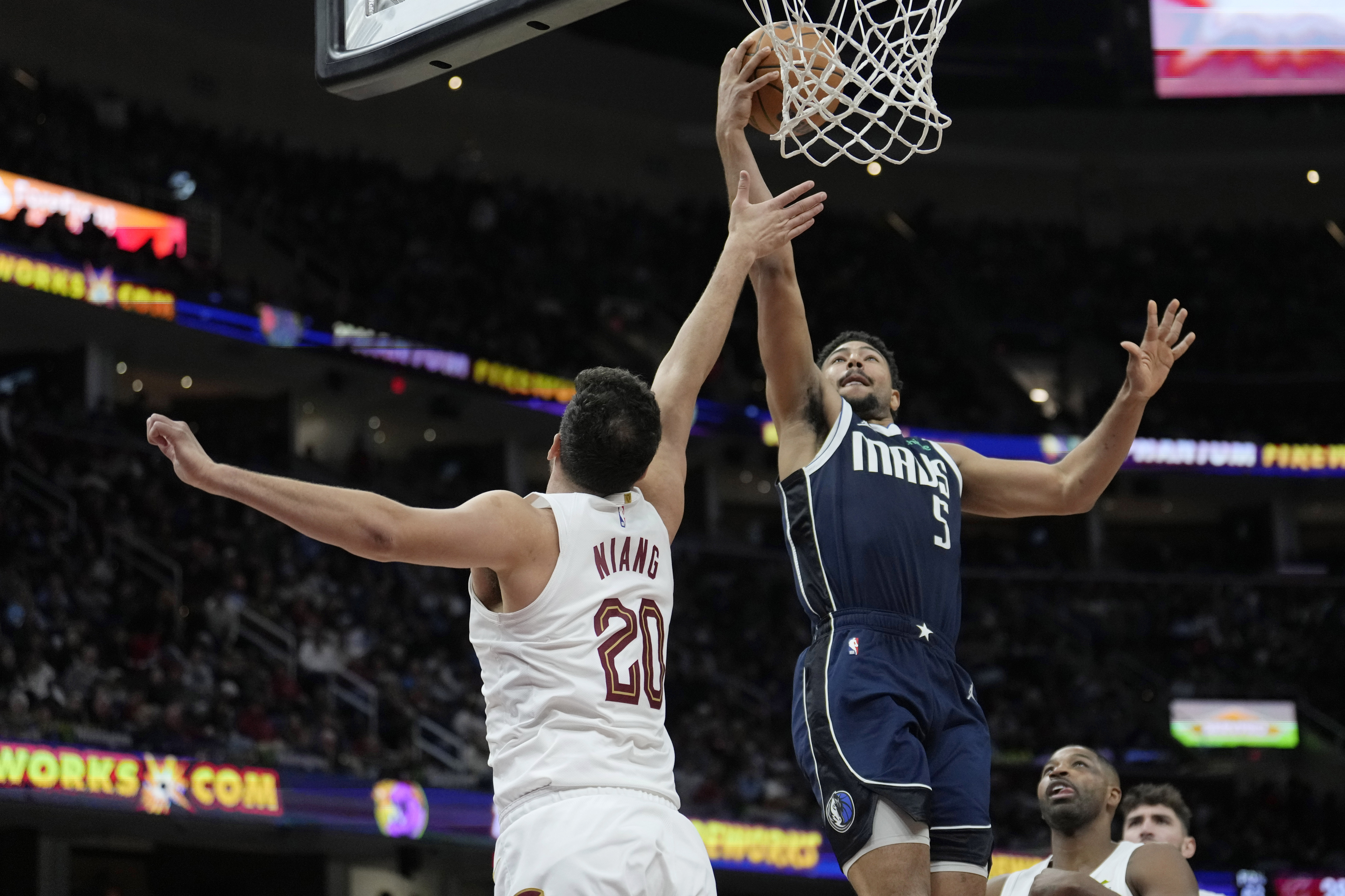 Dallas Mavericks guard Quentin Grimes (5) shoots over Cleveland Cavaliers forward Georges Niang (20) in the second half of an NBA basketball game, Sunday, Feb. 2, 2025, in Cleveland. 