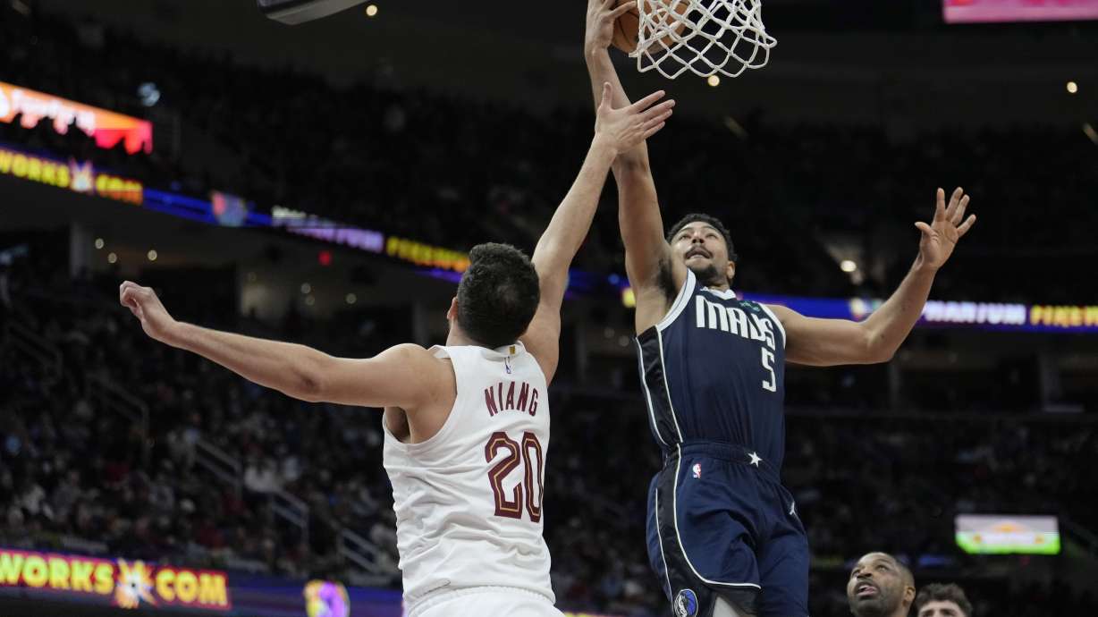Dallas Mavericks guard Quentin Grimes (5) shoots over Cleveland Cavaliers forward Georges Niang (20) in the second half of an NBA basketball game, Sunday, Feb. 2, 2025, in Cleveland.