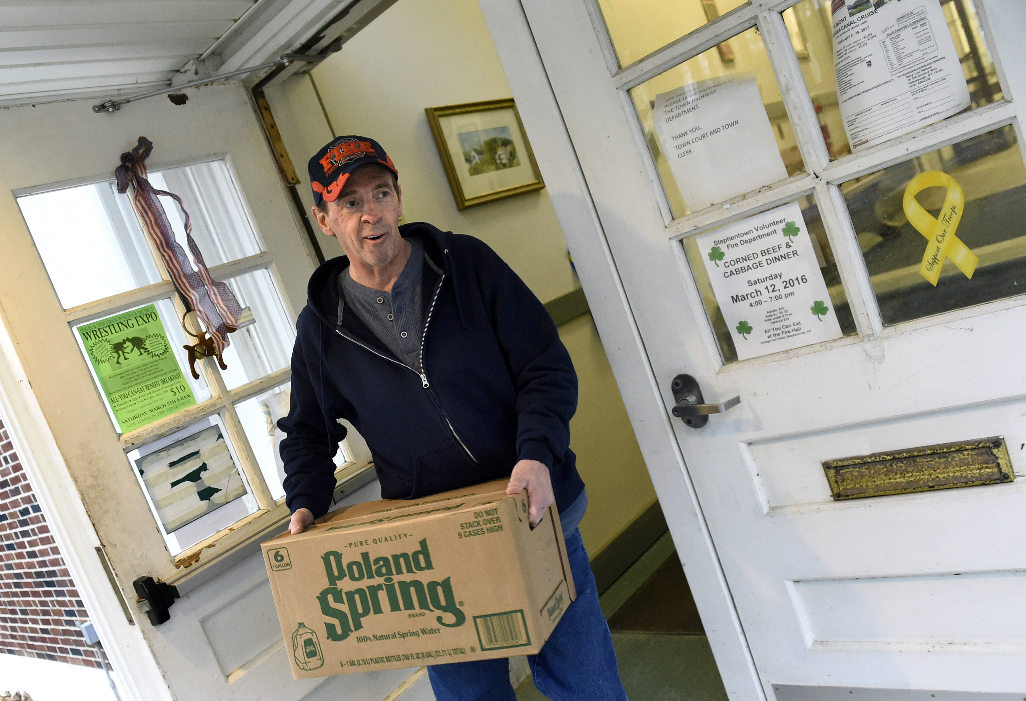 Town Judge Richard Snyder carries bottled water from a distribution center on Feb. 20, 2016, at the Petersburgh Town Hall in Petersburgh, N.Y. Snyder resigned after he got out of jury duty after saying he thinks all defendants are guilty.