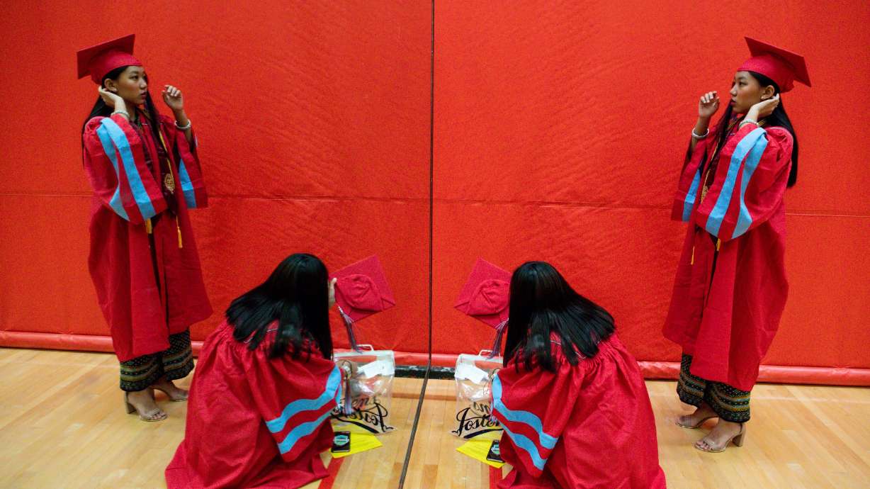 Say Hlawn looks in the mirror while her friend Nguen Sung grabs her cap at Granger High School in West Valley City on May 15, 2020. A Utah lawmaker is proposing that Utah high school students receive a yearlong course on American constitutional government and citizenship for graduation.