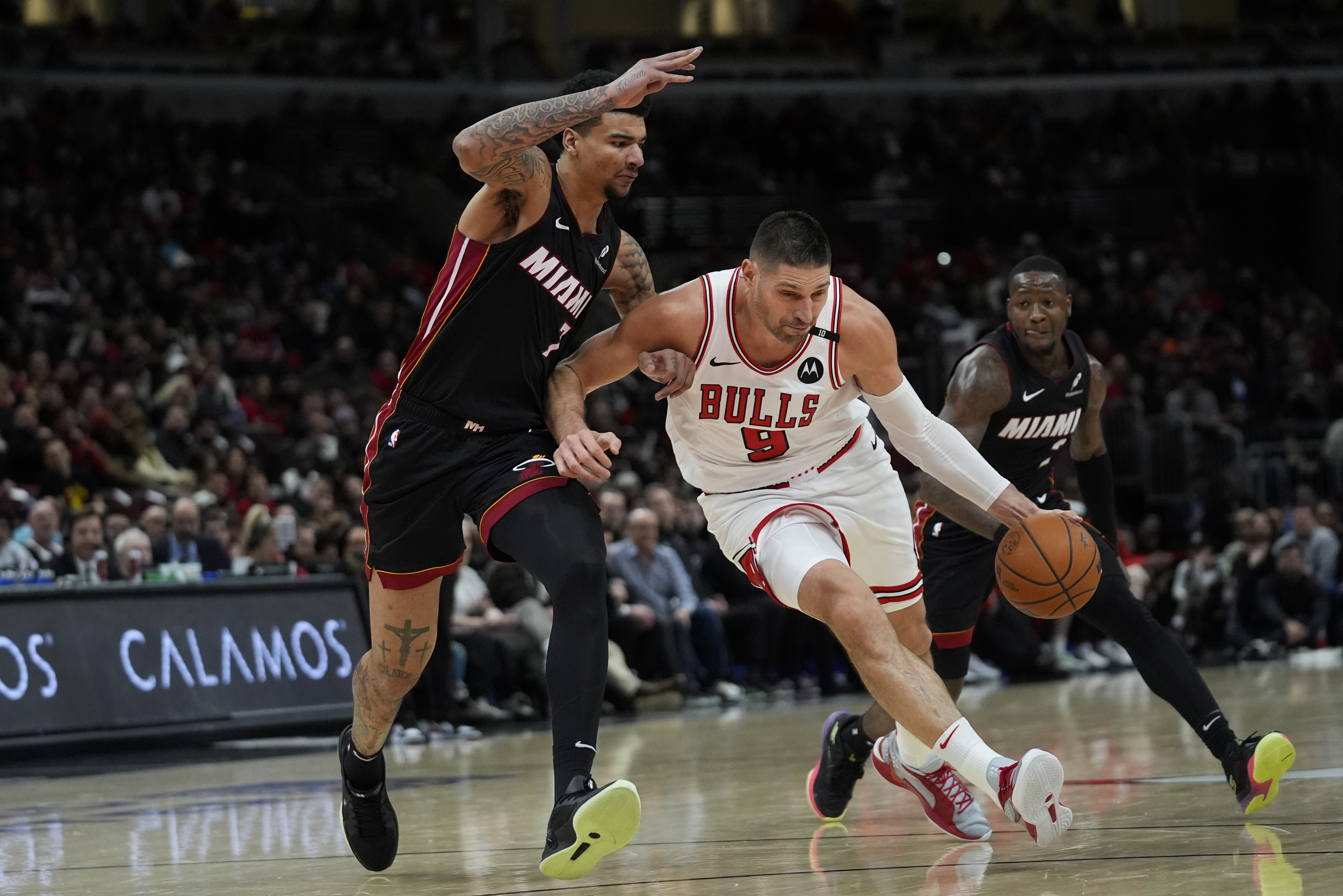 Miami Heat center Kel'el Ware (7), left, guards Chicago Bulls center Nikola Vucevic (9) during the second half of an NBA basketball game Tuesday, Feb. 4, 2025, in Chicago.