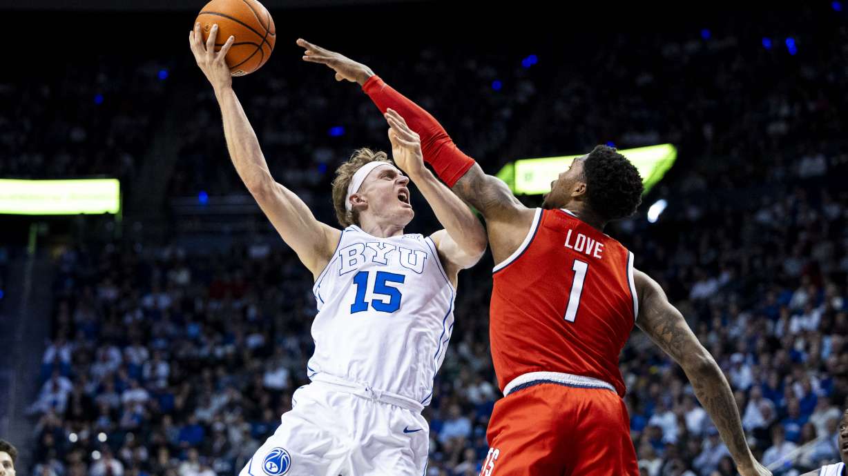BYU Cougars forward Richie Saunders (15) lays the ball up while guarded by Arizona Wildcats guard Caleb Love (1) during an NCAA men’s basketball game held at the Marriott Center in Provo on Tuesday, Feb. 4, 2025.