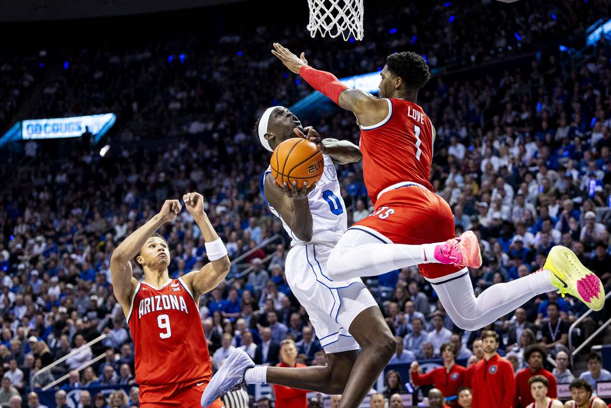 BYU forward Mawot Mag (0) takes a shot while guarded by Arizona guard Caleb Love (1) during an NCAA men’s basketball game held at the Marriott Center in Provo on Tuesday, Feb. 4, 2025.