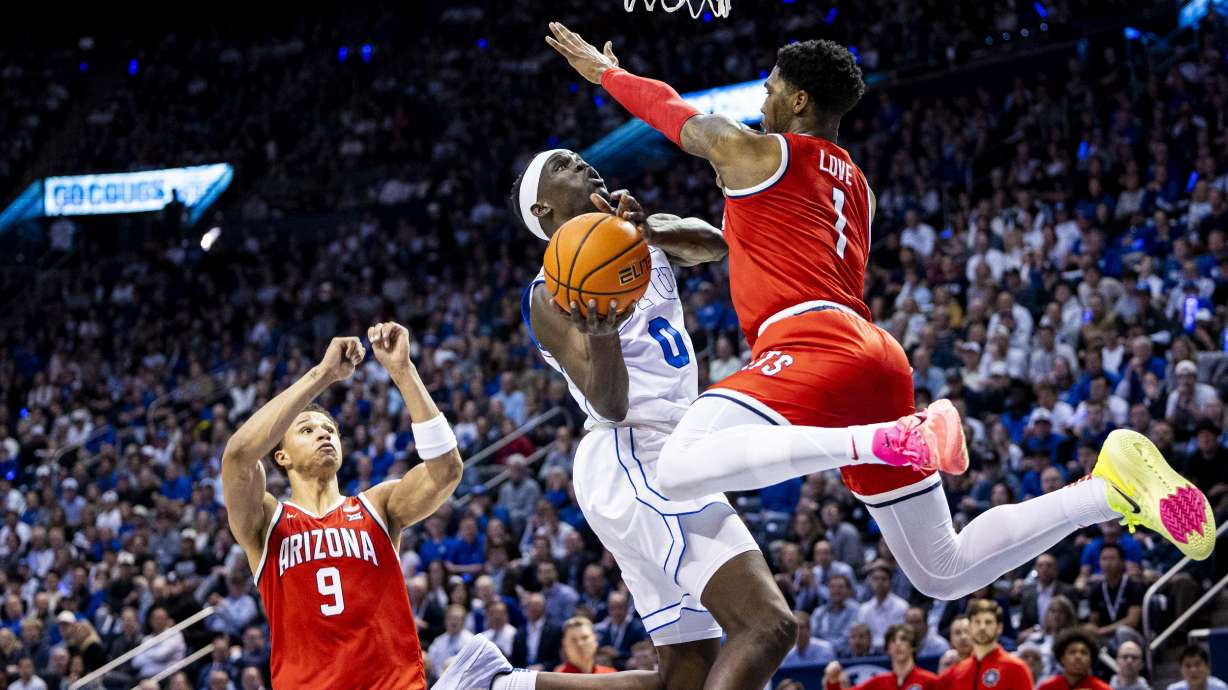 BYU Cougars forward Mawot Mag (0) takes a shot while guarded by Arizona Wildcats guard Caleb Love (1) during an NCAA men’s basketball game held at the Marriott Center in Provo on Tuesday, Feb. 4, 2025.
