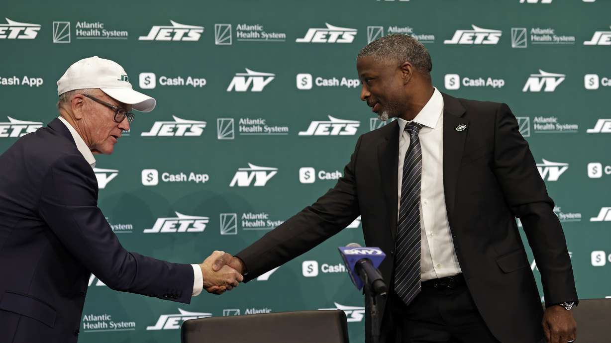 FILE - New York Jets new head coach Aaron Glenn, right, shakes hands with team owner Woody Johnson, left, during a news conference at the NFL football team's training facility Jan. 27, 2025, in Florham Park, N.J.