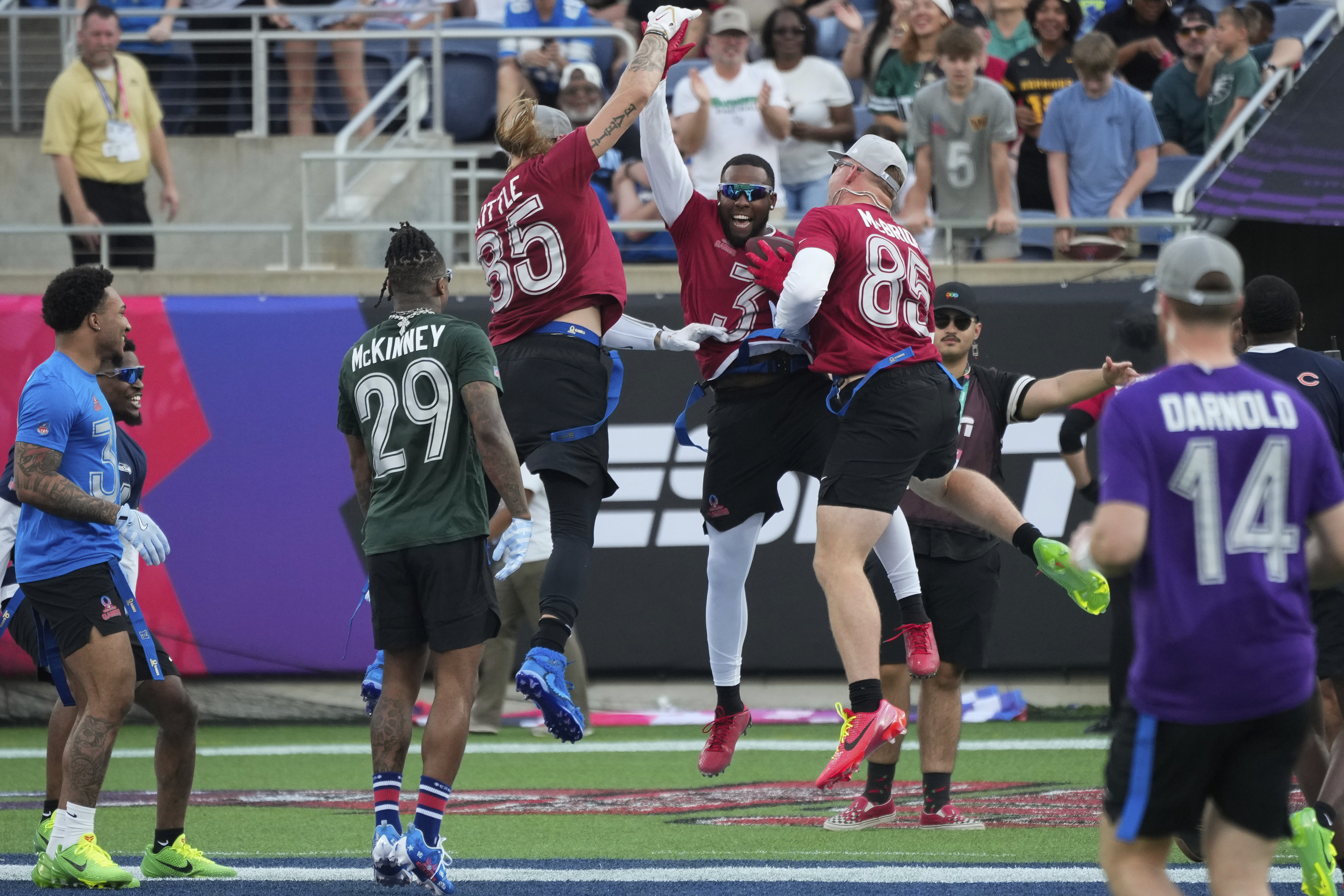 NFC safety Budda Baker (3), of the Arizona Cardinals, celebrates with tight ends George Kittle, of the San Francisco 49ers, and Trey McBride, of the Cardinals, after returning an interception for a touchdown during the flag football event at the NFL Pro Bowl, Sunday, Feb. 2, 2025, in Orlando. 