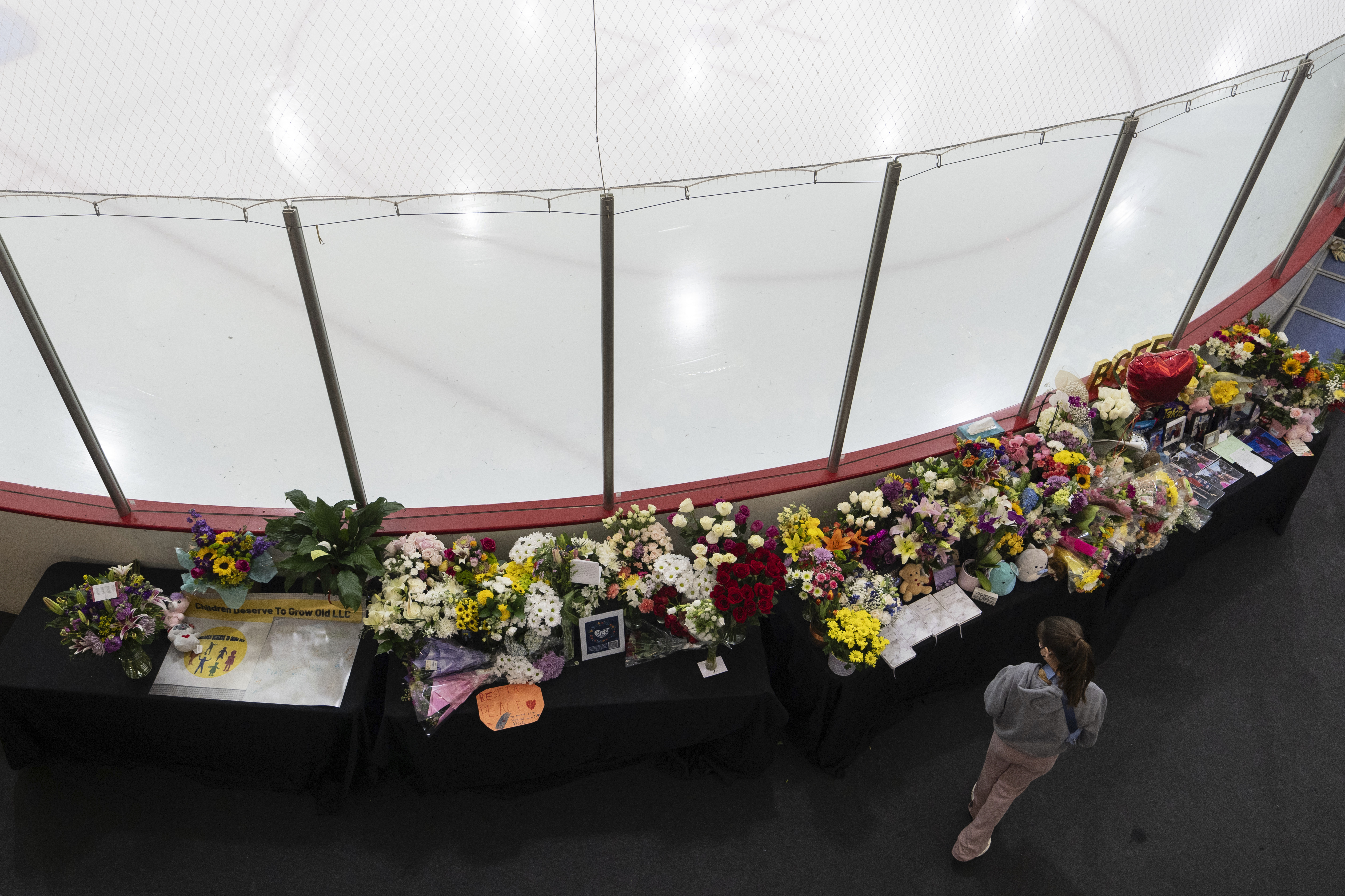 A memorial is seen along the boards at MedStar Capitals Iceplex Sunday, Feb. 2, 2025, in Arlington, Va., for the figure skaters who were among the 67 victims of a mid-air collision between an Army helicopter and an American Airlines flight from Kansas. 