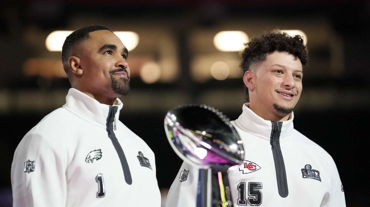 Philadelphia Eagles quarterback Jalen Hurts (1) and Kansas City Chiefs quarterback Patrick Mahomes (15) pose with the trophy during Super Bowl 59 Opening Night, Monday, Feb. 3, 2025, in New Orleans, ahead of the NFL football game between the Philadelphia Eagles and the Kansas City Chiefs Sunday.