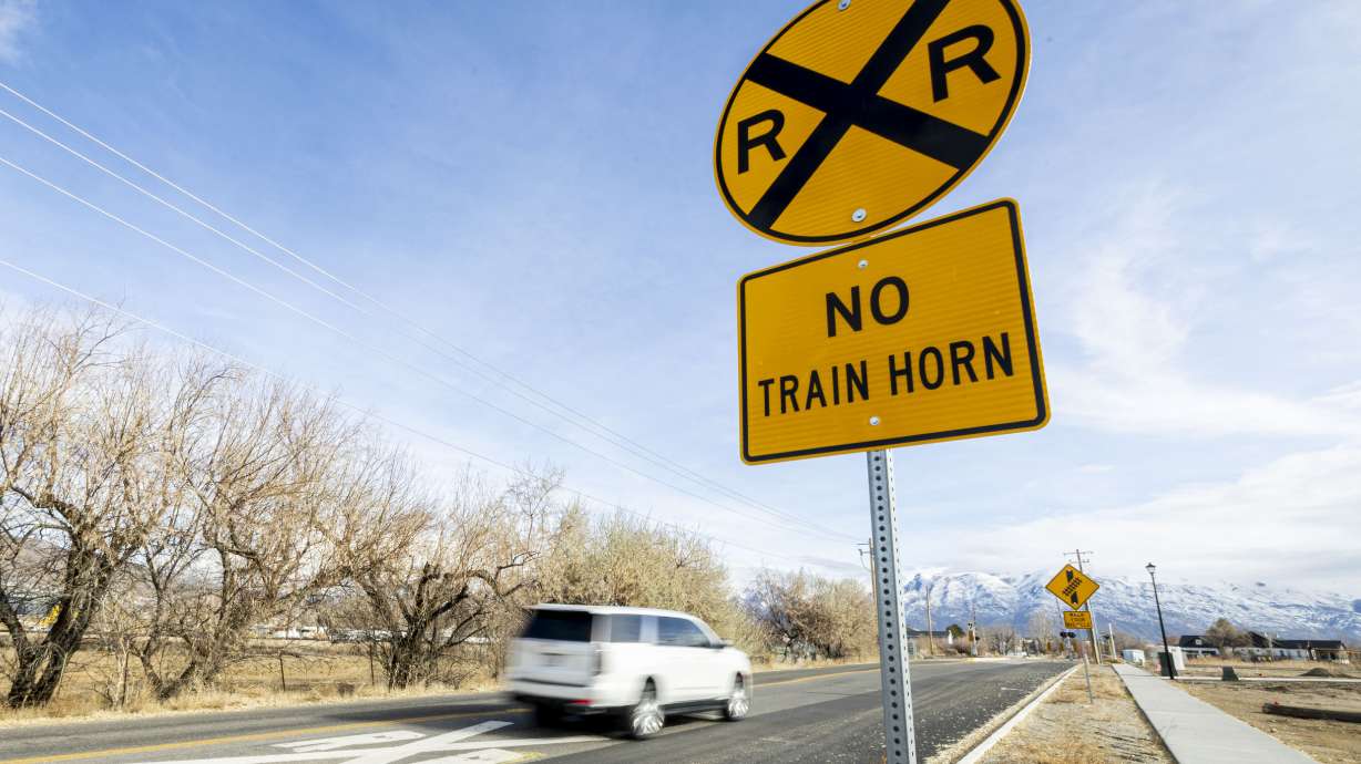 A vehicle travels along 1500 North and toward a "quiet zone" railroad crossing in Lehi on Jan. 2. A quiet zone from Salt Lake City to Ogden remains held up with a new waiver request being sought in the process to reinstate it.