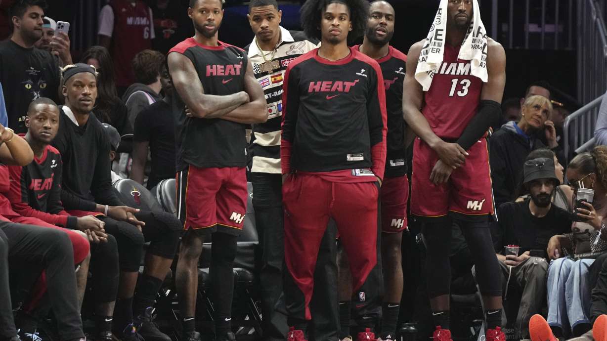 Miami Heat forward Jimmy Butler, second from left, and center Bam Adebayo (13) watch with their teammates during the second half of an NBA basketball game against the Portland Trail Blazers, Tuesday, Jan. 21, 2025, in Miami.