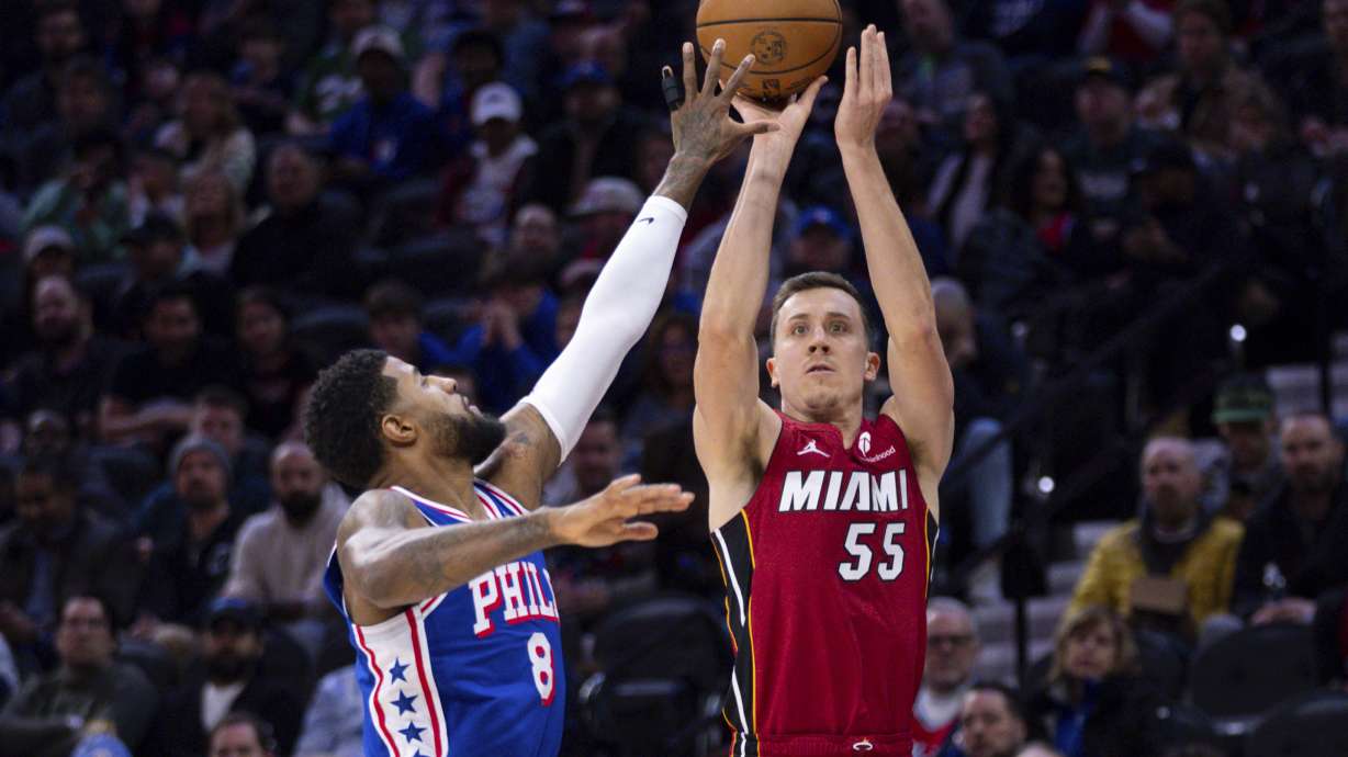 Miami Heat's Duncan Robinson, right, shoots the ball with Philadelphia 76ers' Paul George, left, defending during the first half of an NBA basketball game, Wednesday, Feb. 5, 2025, in Philadelphia.