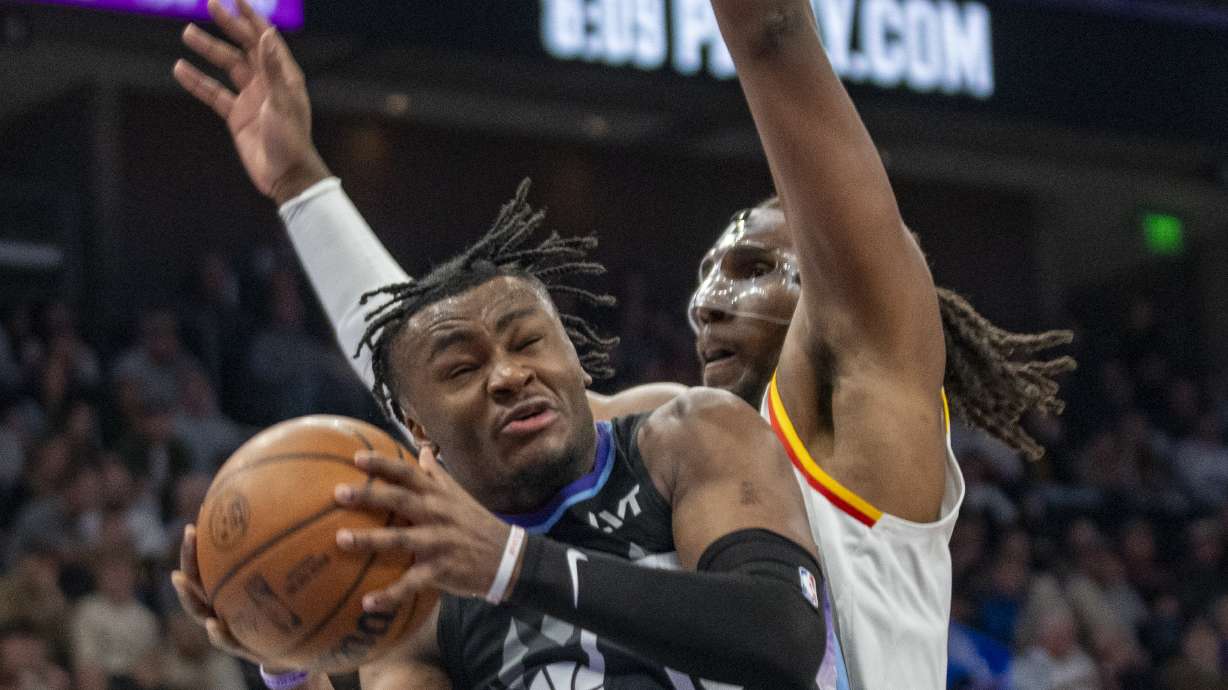 Utah Jazz guard Isaiah Collier, left, is guard by Golden State Warriors forward Kevon Looney (5), during the first half of an NBA basketball game against the Utah Jazz Wednesday, Feb. 5, 2025, in Salt Lake City.