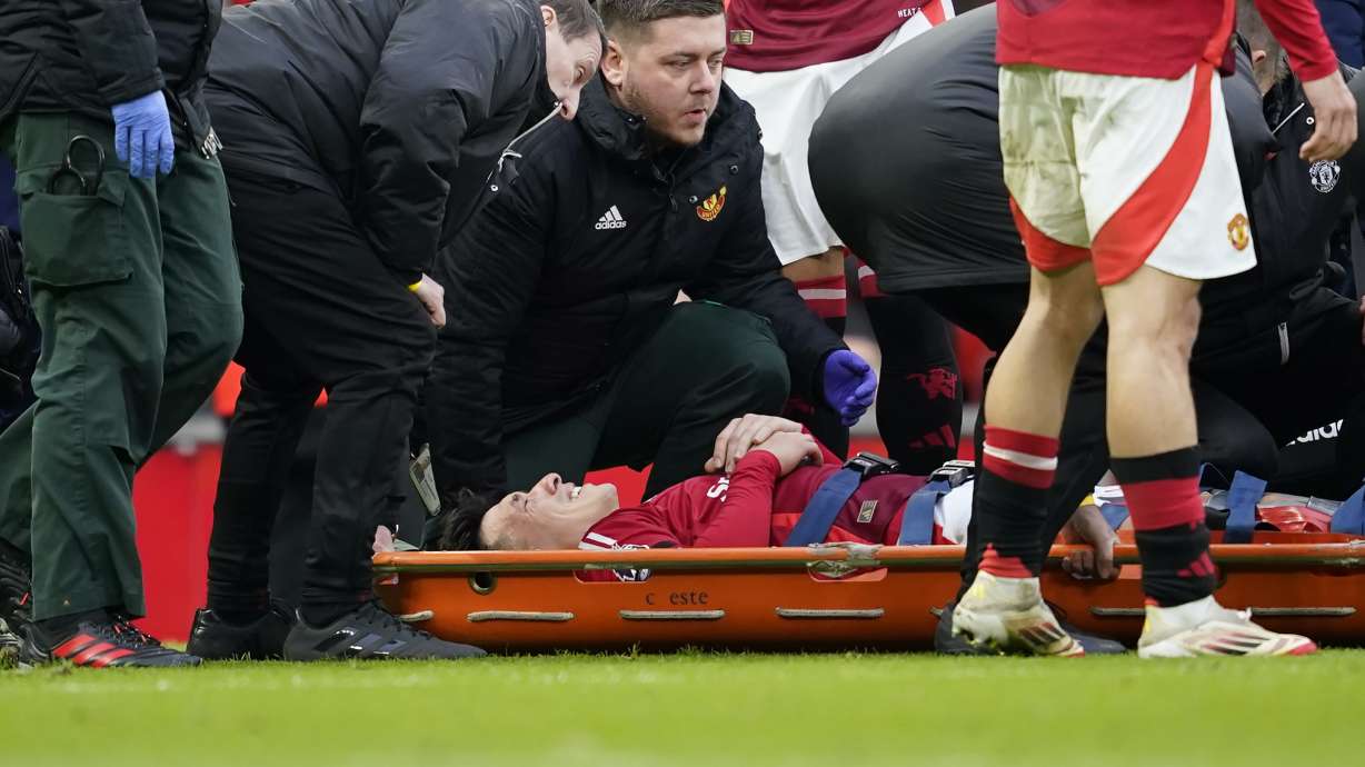 Manchester United's Lisandro Martinez reacts in pain as he lies on a stretcher after an injury during the English Premier League soccer match between Manchester United and Crystal Palace at Old Trafford stadium in Manchester, England, Sunday, Feb. 2, 2025.