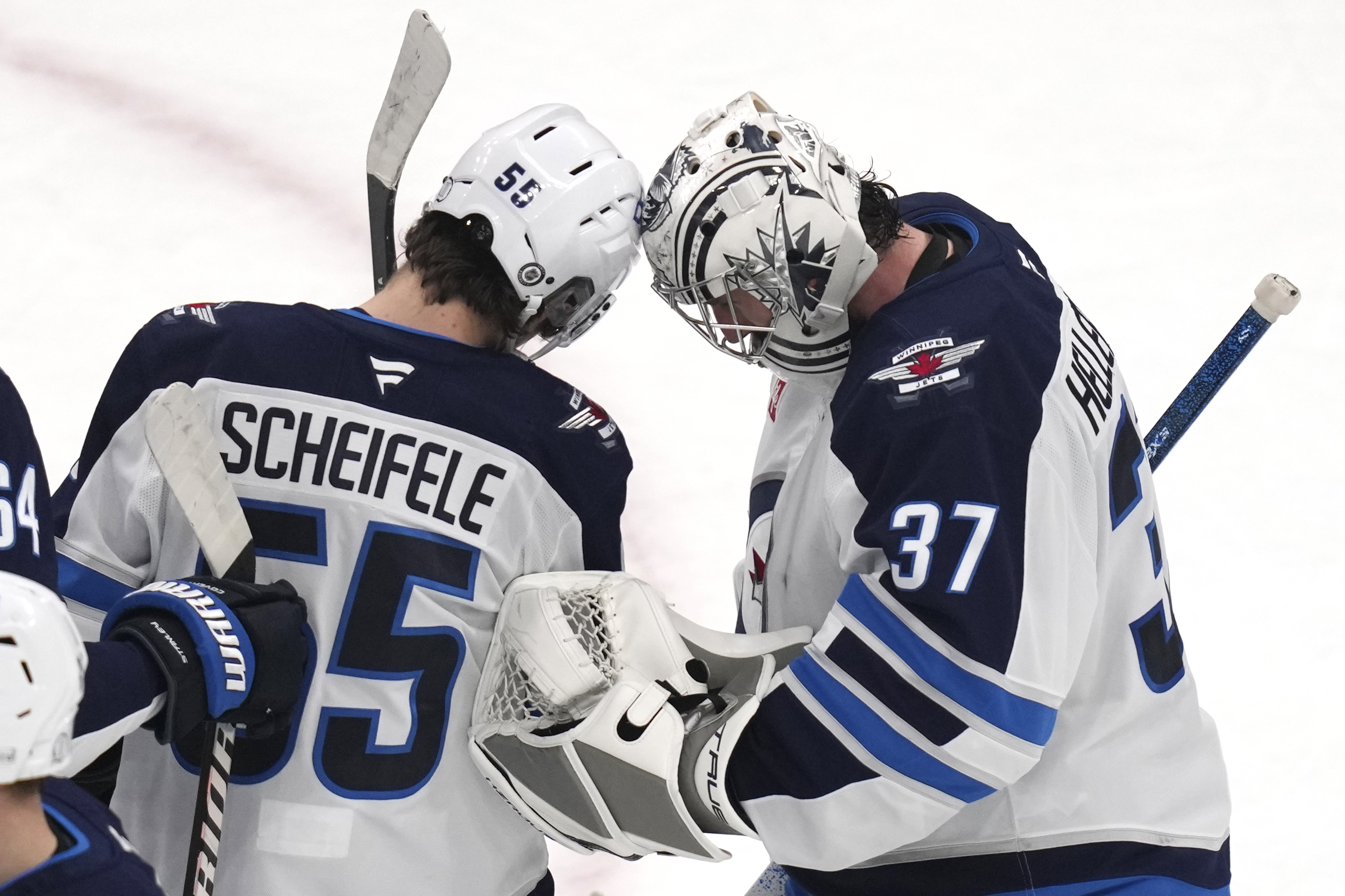 Winnipeg Jets center Mark Scheifele (55) congratulates goaltender Connor Hellebuyck (37) after they defeated the Boston Bruins in an NHL hockey game, Thursday, Jan. 30, 2025, in Boston.