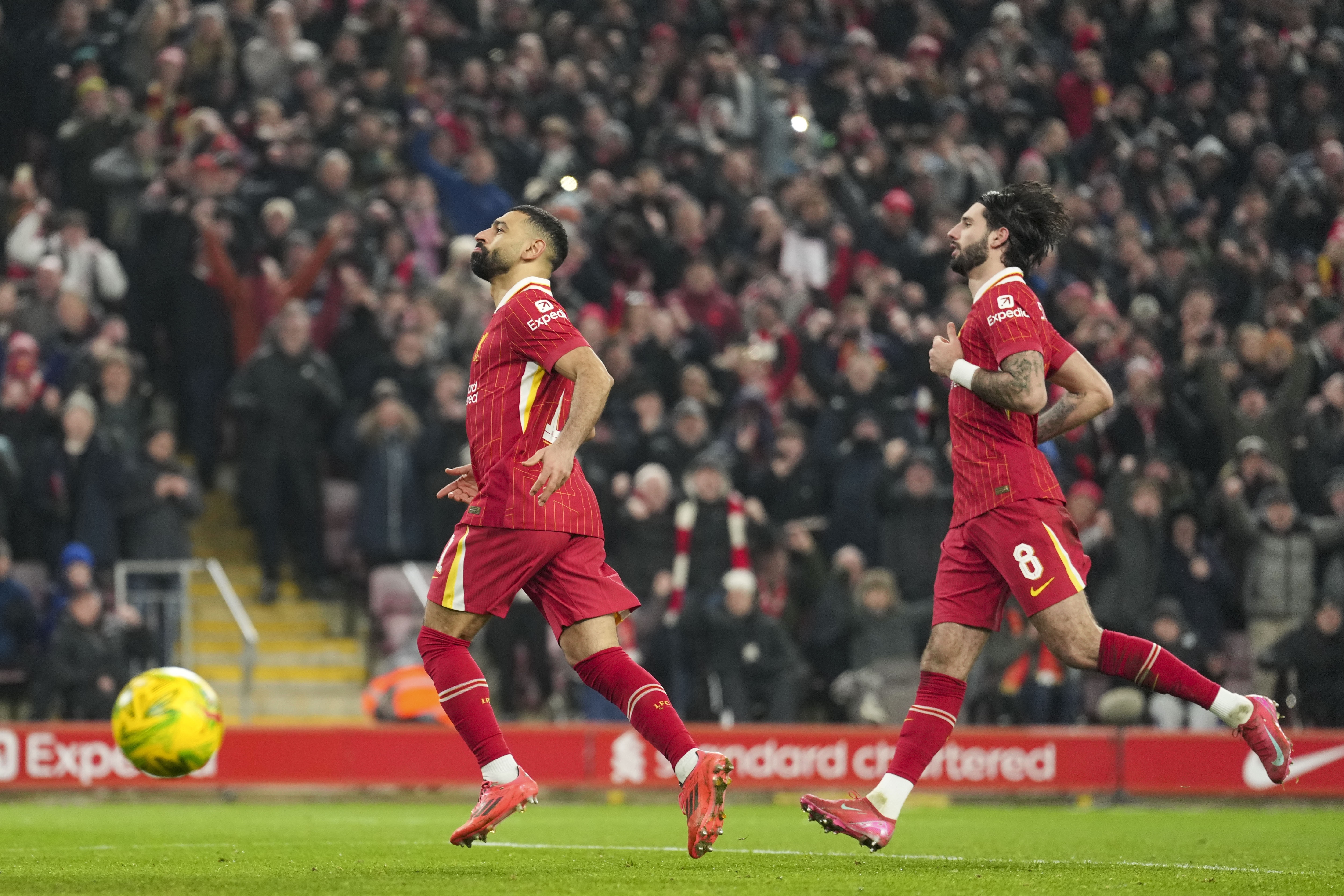 Liverpool's Mohamed Salah, left, celebrates with Dominik Szoboszlai after scoring the second goal from the penalty spot during the English League Cup semifinal second leg soccer match between Liverpool and Tottenham Hotspur at Anfield Stadium in Liverpool, England, Thursday, Feb. 6, 2025.