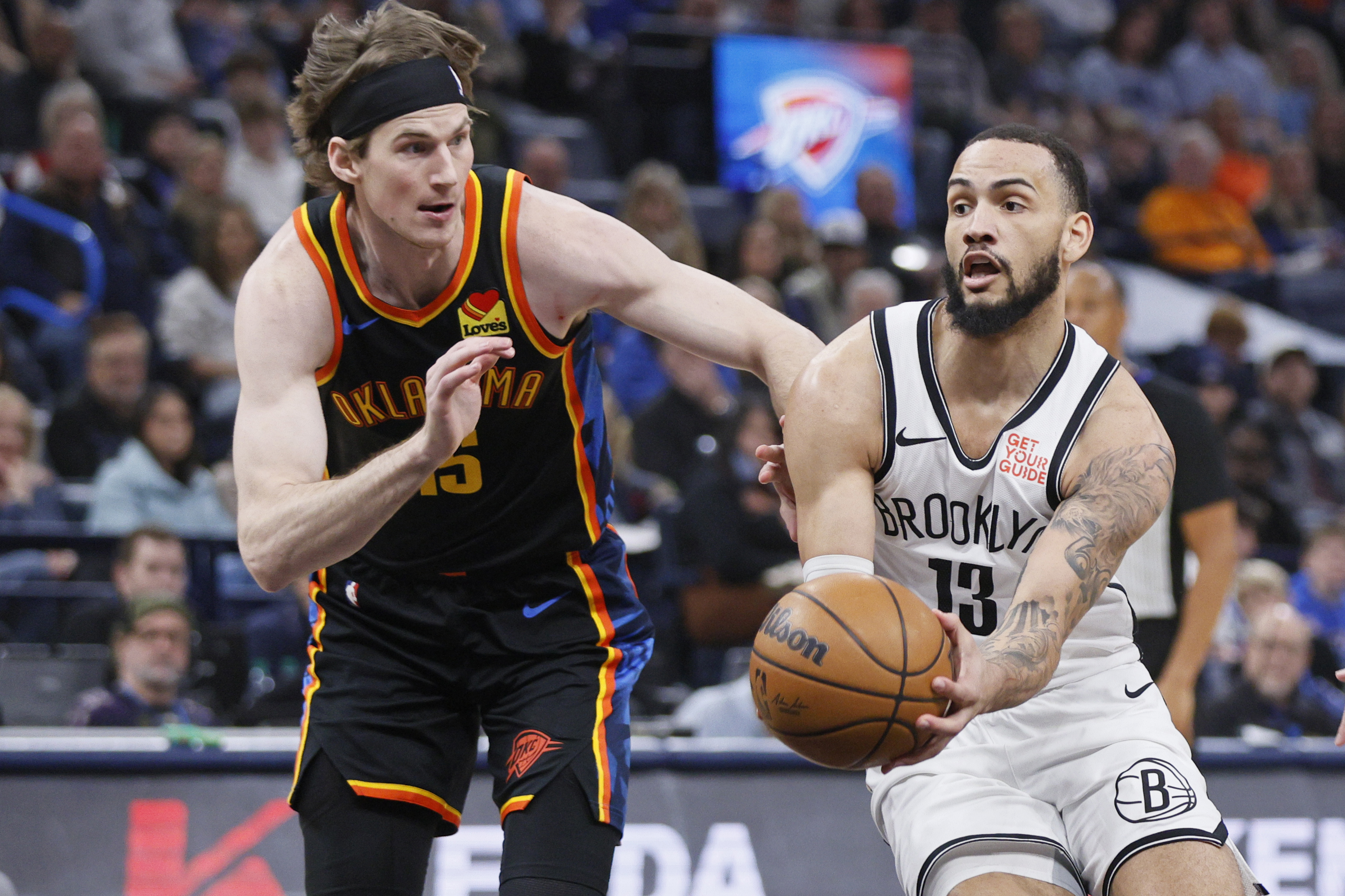 Brooklyn Nets guard Tyrese Martin (13) drives against Oklahoma City Thunder center Branden Carlson, left, during the first half of an NBA basketball game Sunday, Jan. 19, 2025, in Oklahoma City.