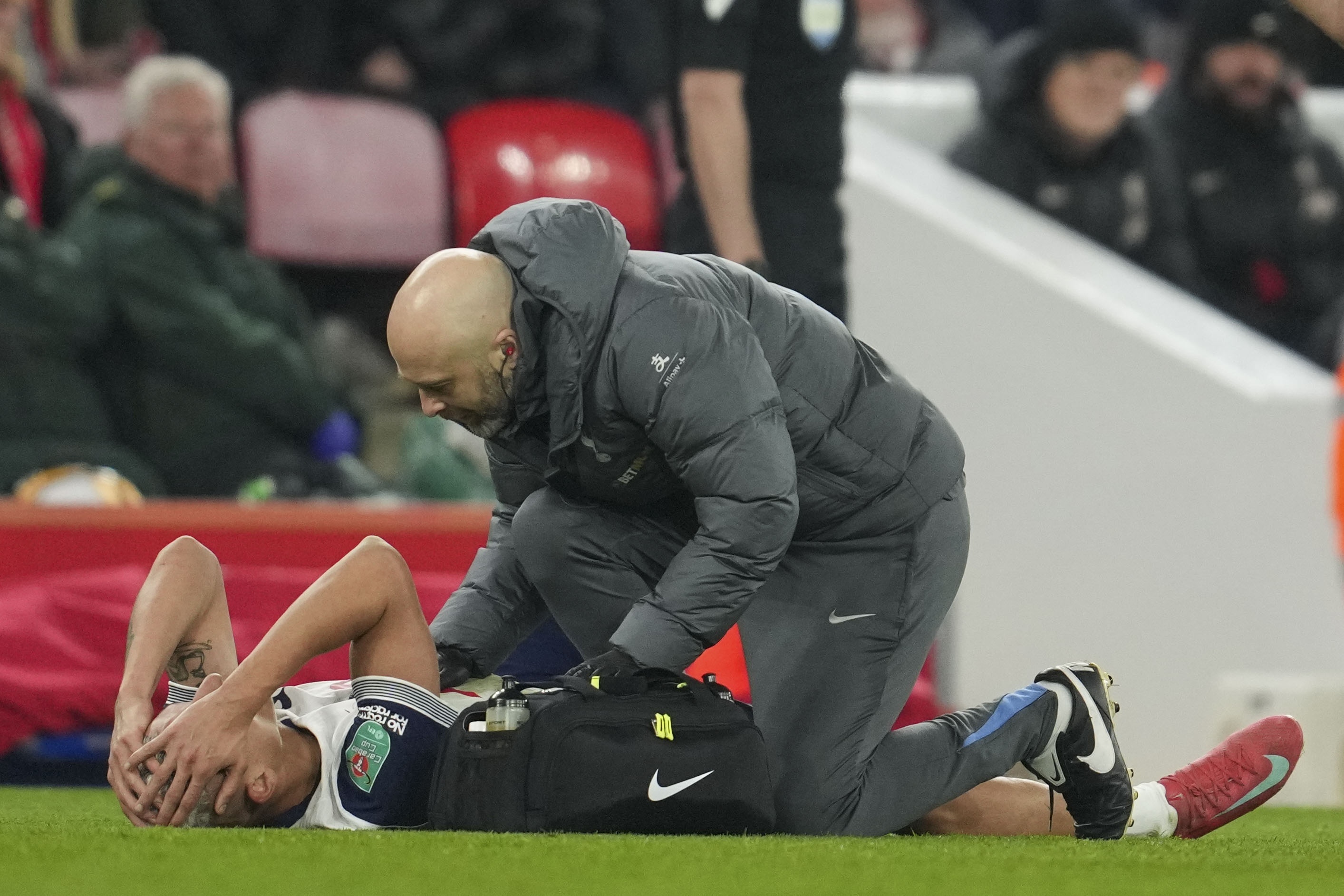 Tottenham's Richarlison gets treatment before leaving the field injured during the English League Cup semifinal second leg soccer match between Liverpool and Tottenham Hotspur at Anfield Stadium in Liverpool, England, Thursday, Feb. 6, 2025.
