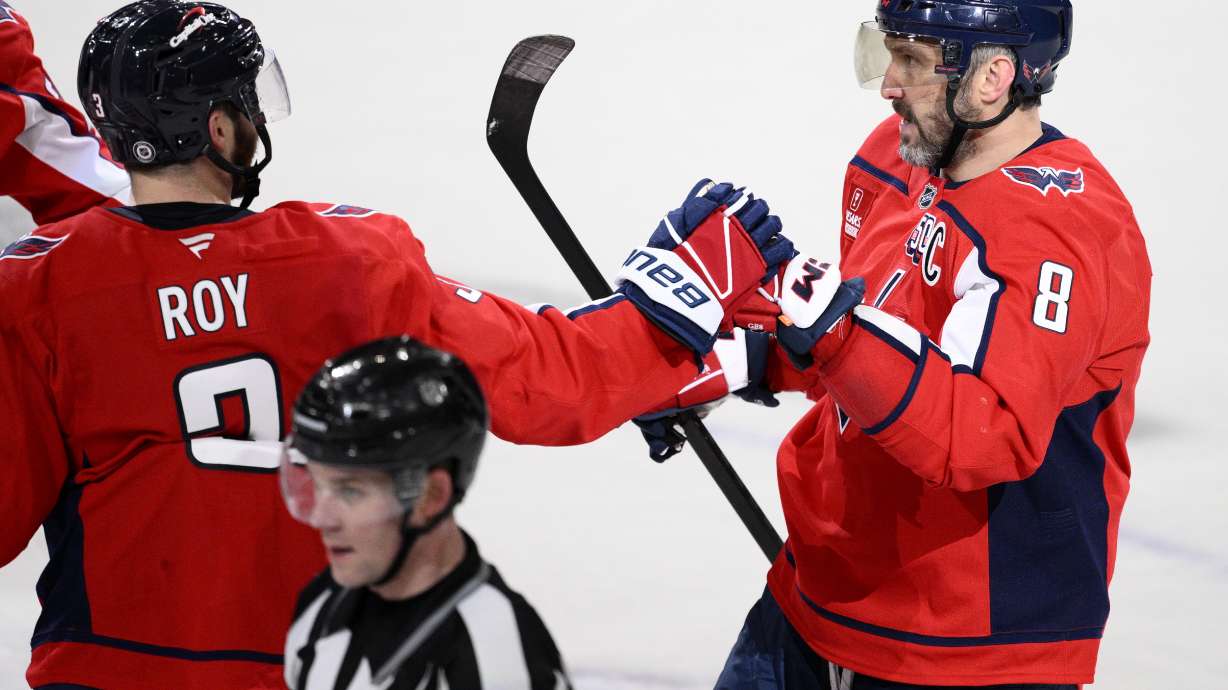 Washington Capitals left wing Alex Ovechkin (8) celebrates his empty net goal with defenseman Matt Roy (3) during the third period of an NHL hockey game against the Florida Panthers, Tuesday, Feb. 4, 2025, in Washington.
