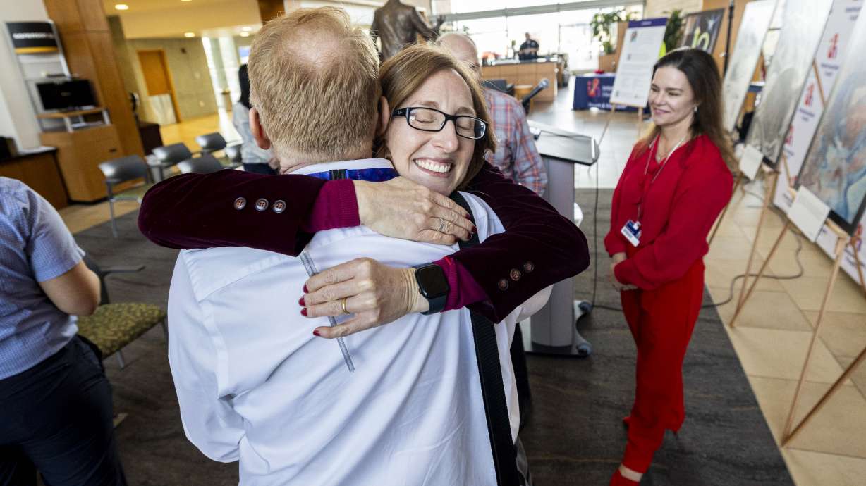 Kimberleigh Collins-Peynaud, an artist and heart attack survivor, hugs Dr. Kent Meredith, Intermountain Health interventional cardiologist, after a press conference concerning heart disease in women at Intermountain Medical Center in Murray Thursday.
