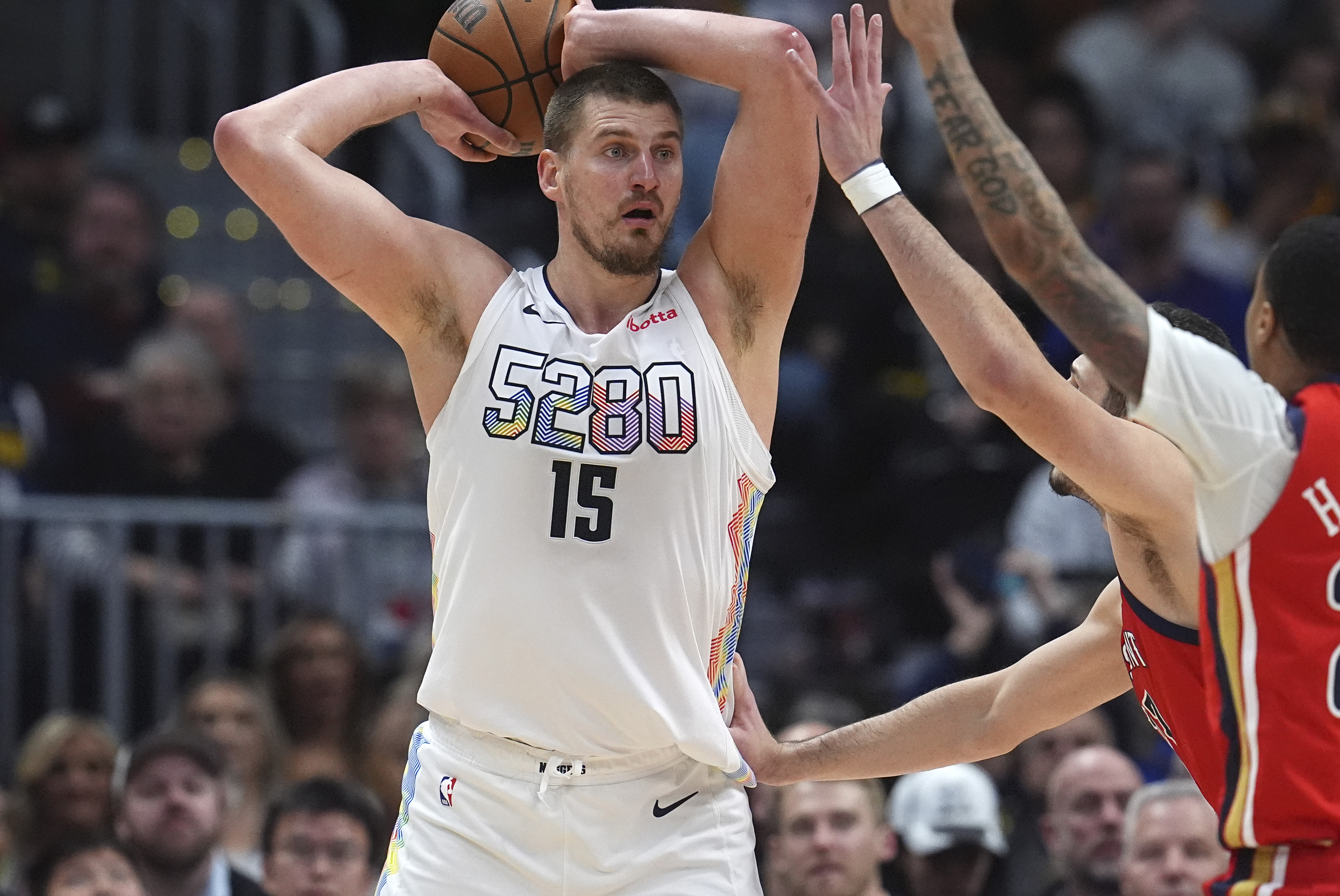 Denver Nuggets center Nikola Jokic, left, looks to pass the ball as New Orleans Pelicans guard Jordan Hawkins defends in the second half of an NBA basketball game Wednesday, Feb. 5, 2025, in Denver.