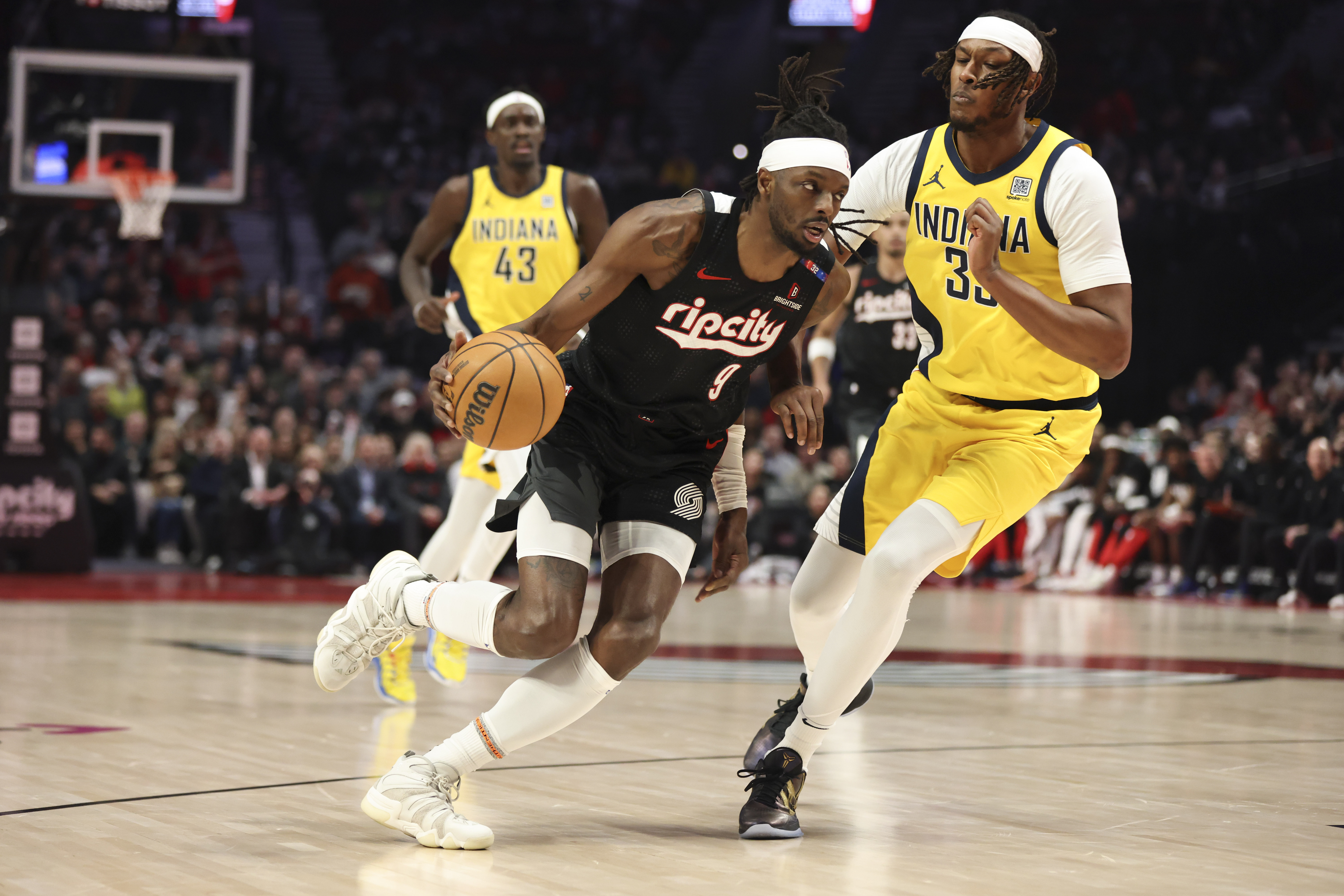 Portland Trail Blazers forward Jerami Grant (9) drives to the basket as Indiana Pacers center Myles Turner (33) defends during the first half of an NBA basketball game Tuesday, Feb. 4, 2025, in Portland, Ore.
