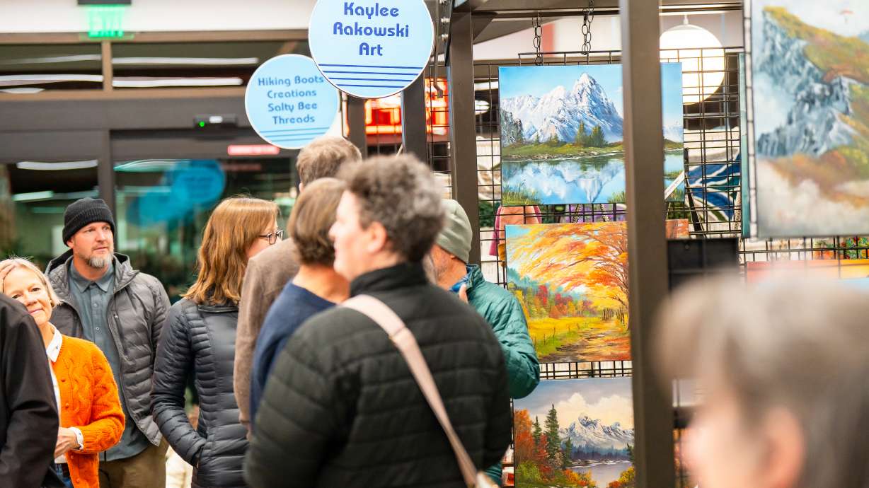 People walk through art booths at the Art Market at Millcreek Common on Jan. 24.