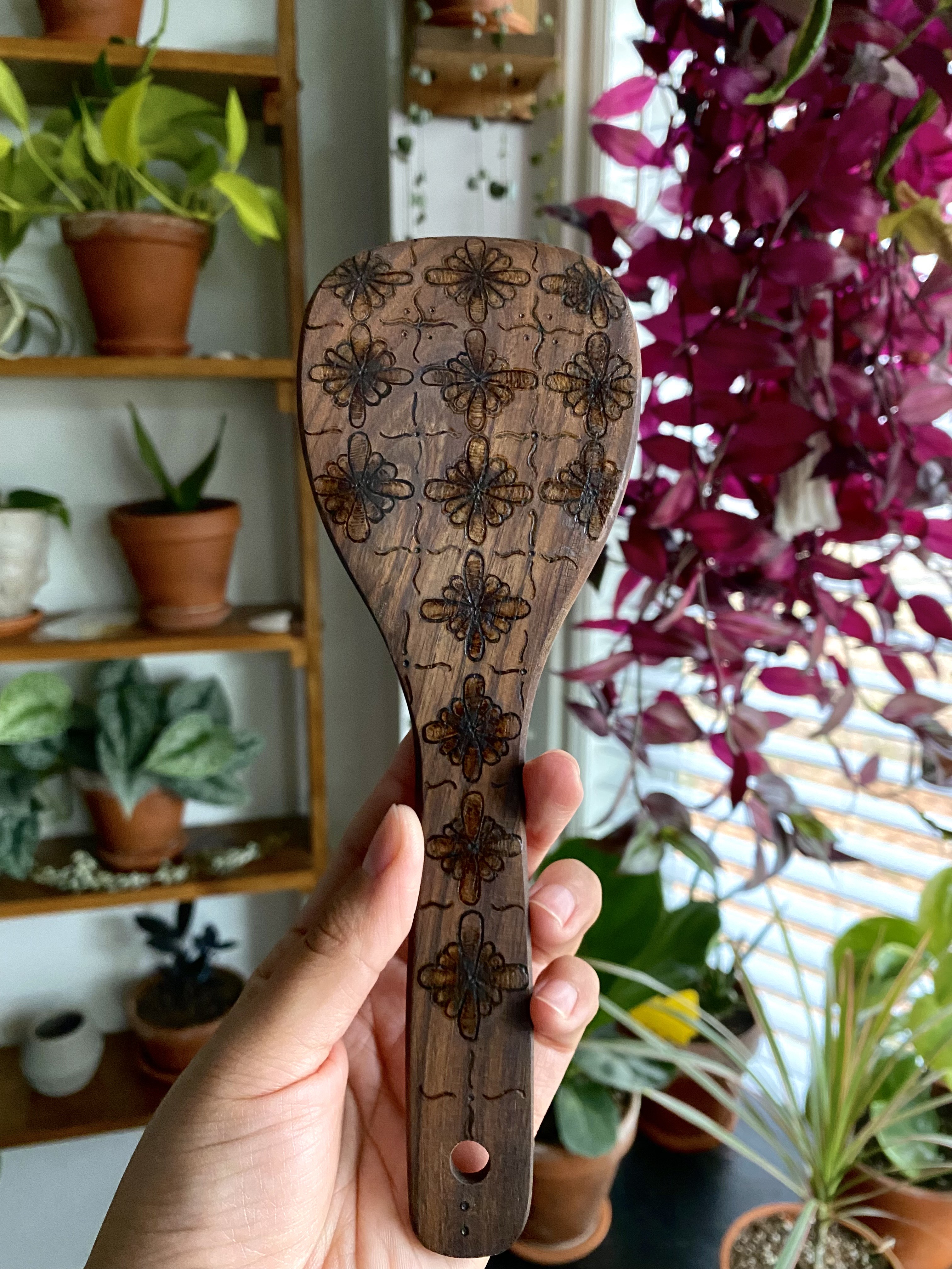 An original wood-burn design on a wooden utensil by Miriam Gutierrez.