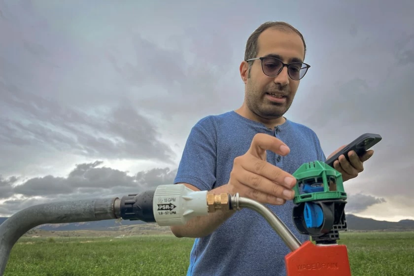 USU researcher Maziyar Vaez Roudbari demonstrates a water-efficient rotator nozzle he’s testing at a farm in Wayne County, Aug. 22, 2024. Showing Utah farmers which equipment can squeeze the best possible harvests from their water could help sustain them in a drier future.