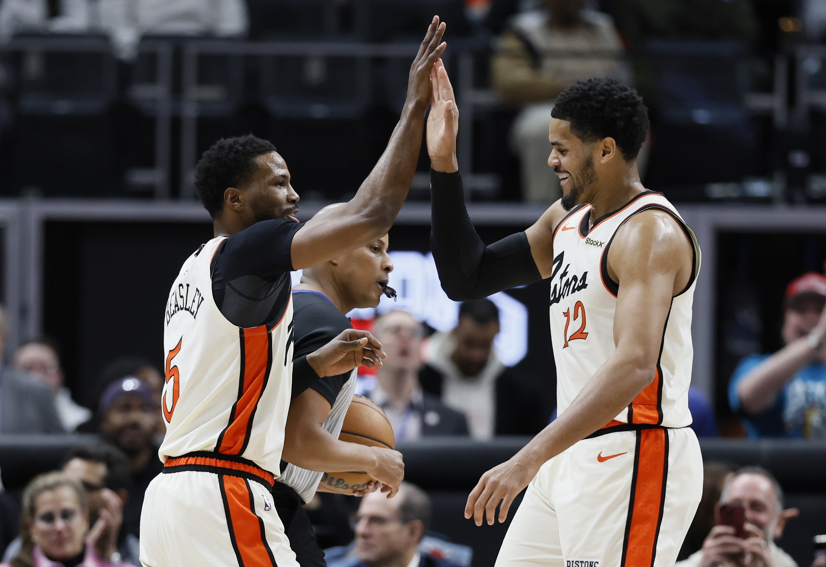 Detroit Pistons guard Malik Beasley (5) receives a high-five from forward Tobias Harris (12) after hitting a three-point shot against the Philadelphia 76ers during the first half of an NBA basketball game Friday, Feb. 7, 2025, in Detroit.