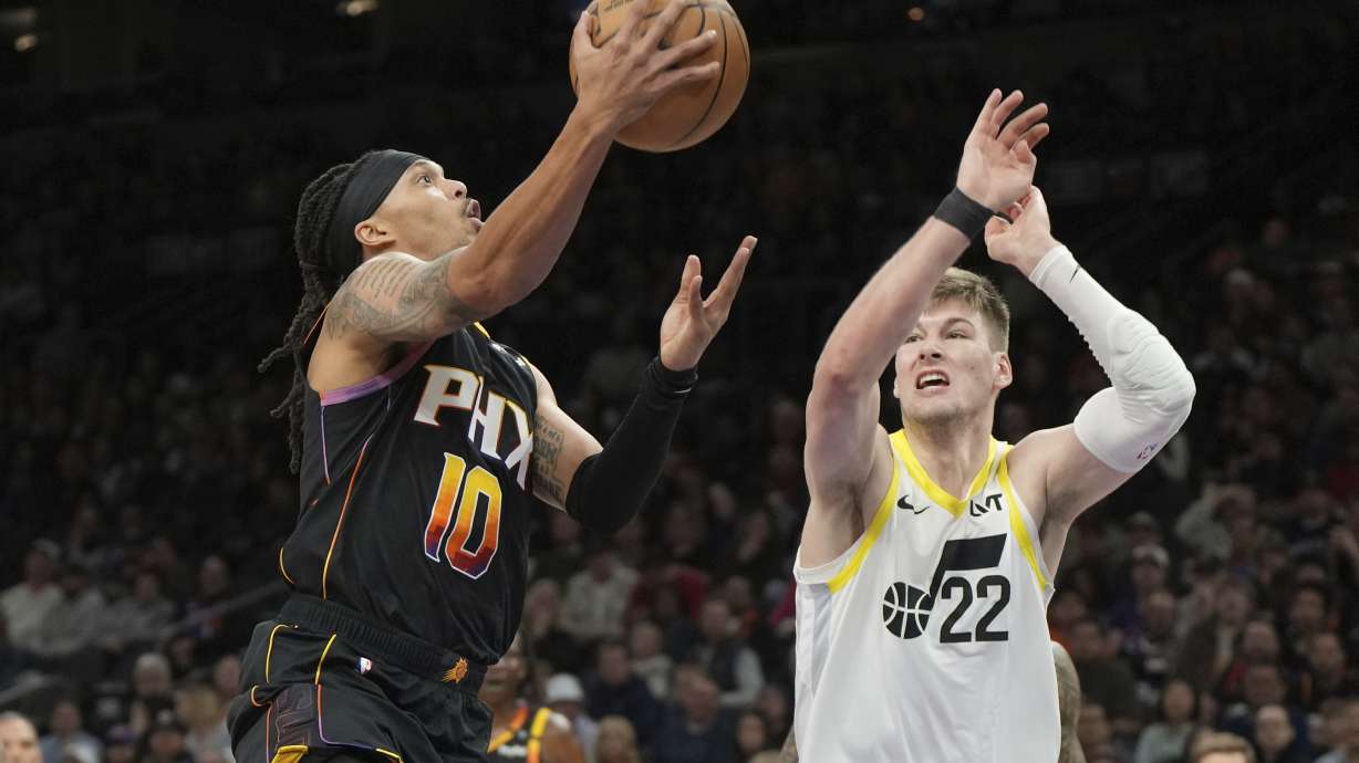 Phoenix Suns guard Damion Lee (10) drives against Utah Jazz forward Kyle Filipowski (22) during the first half of an NBA basketball game, Friday, Feb. 7, 2025, in Phoenix.