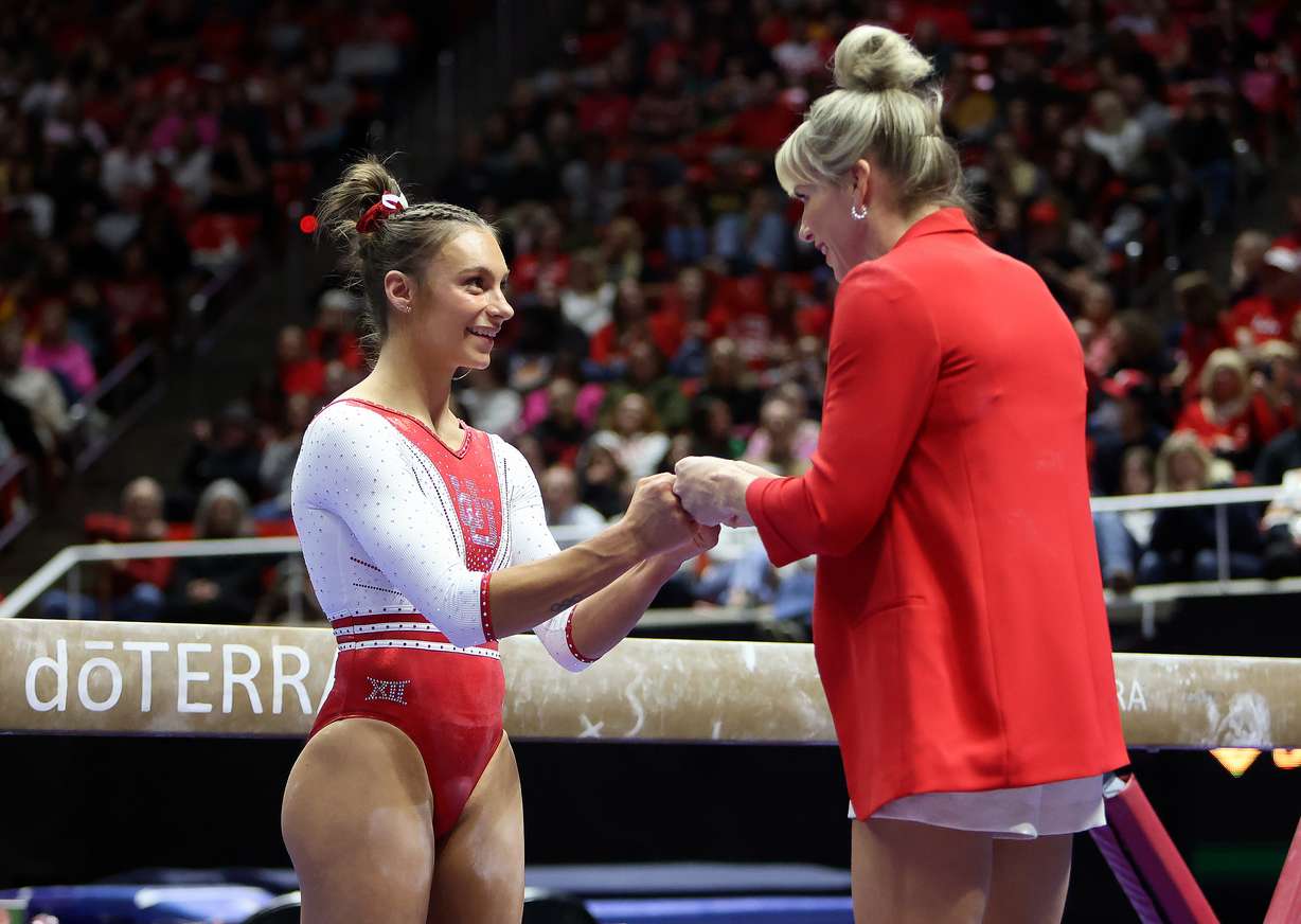 Utah’s Grace McCallum fist bumps Utah gymnastics head coach Carly Dockendorf before competing on the beam during a gymnastics meet against Arizona at the Huntsman Center in Salt Lake City on Friday, Feb. 7, 2025. Utah won.