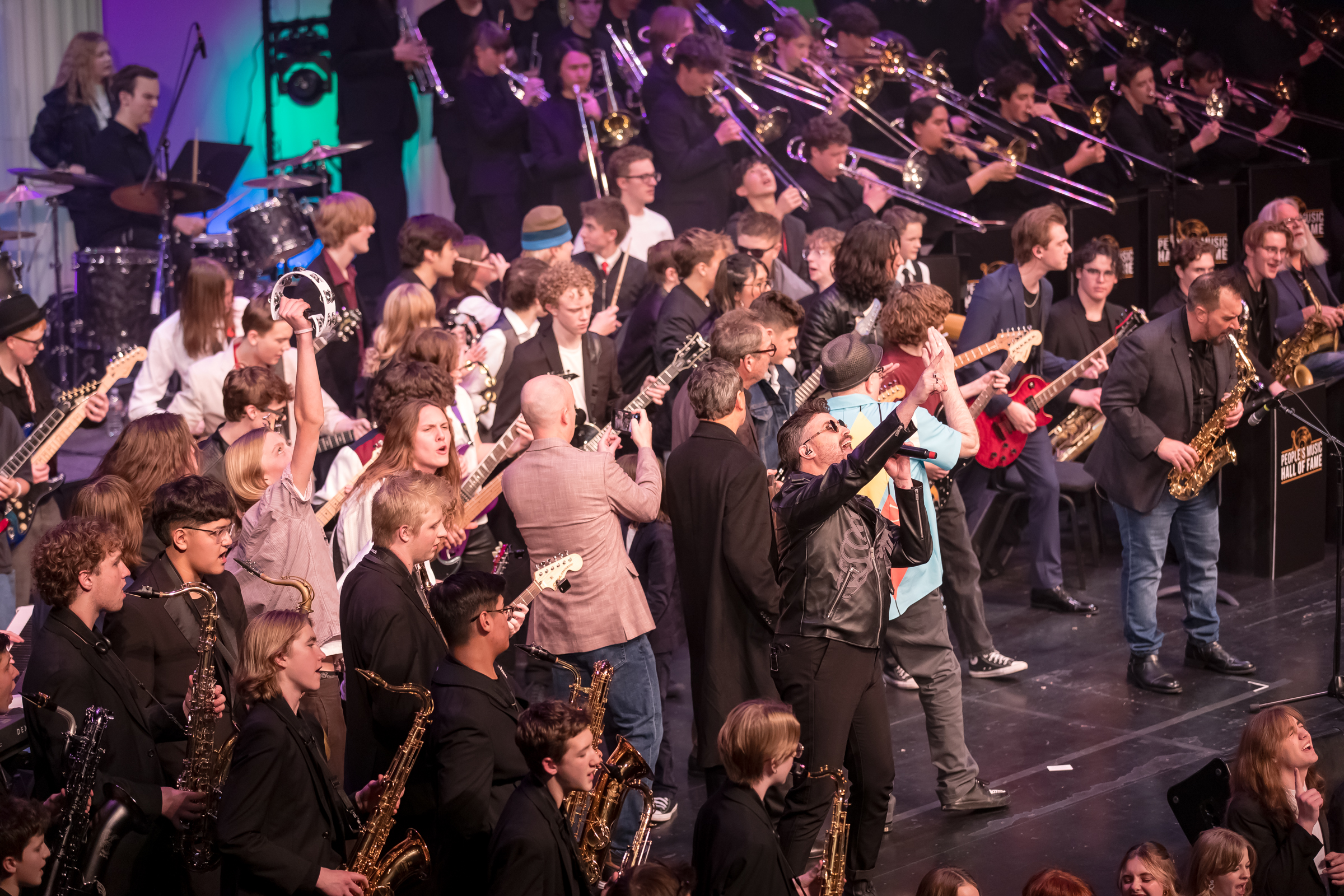 Tyler Glenn, of Neon Trees, sings alongside about 200 students from Caleb Chapman's Soundhouse during an event to welcome Huey Lewis into the People's Music Hall of Fame at Eccles Theater on Friday.