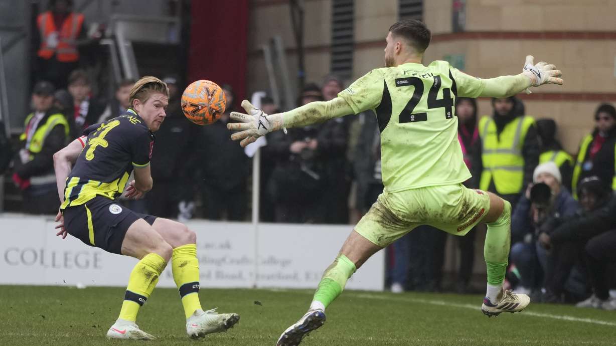 Manchester City's Kevin De Bruyne, left, scores his side's second goal during the English FA Cup fourth round soccer match between Leyton Orient and Manchester City at the Gaughan Group Stadium in London, England, Saturday, Feb. 8, 2025.