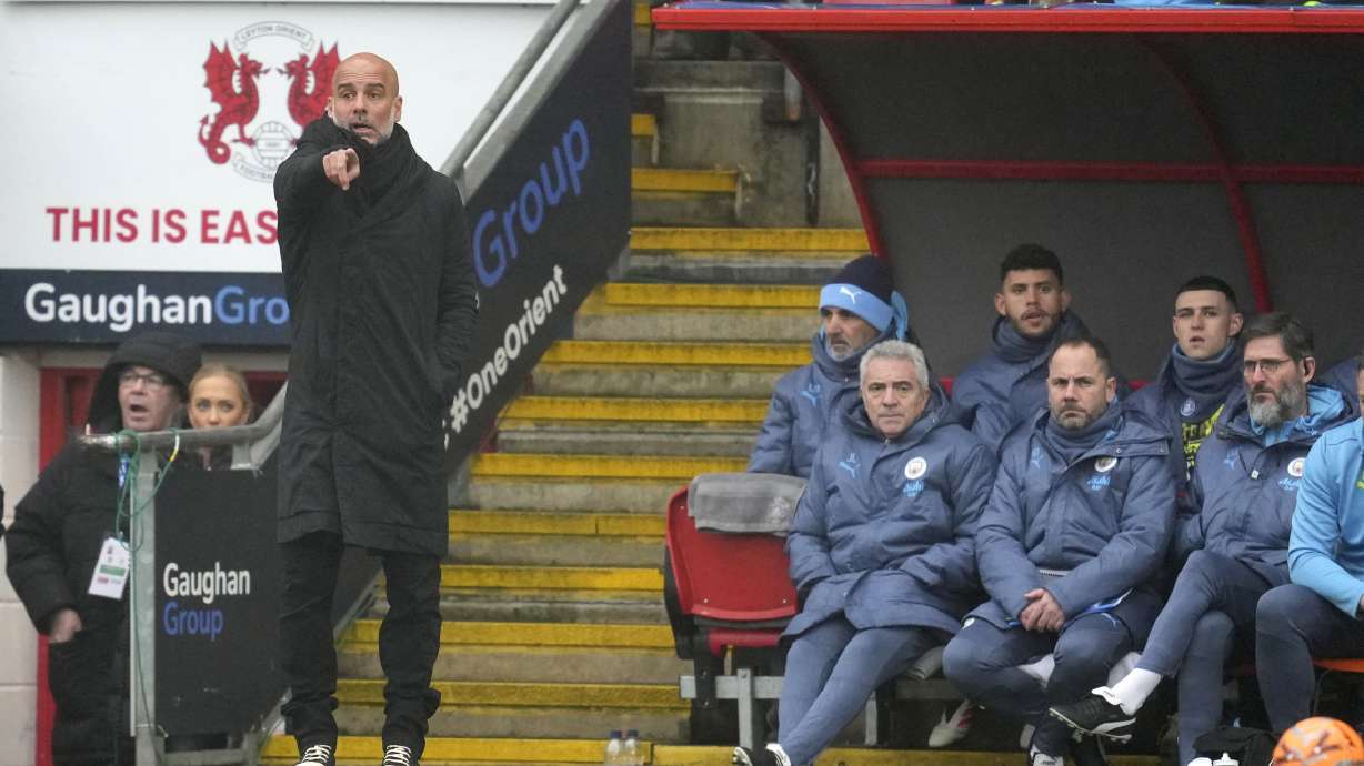 Manchester City's head coach Pep Guardiola, left, gives instructions from the side line during the English FA Cup fourth round soccer match between Leyton Orient and Manchester City at the Gaughan Group Stadium in London, England, Saturday, Feb. 8, 2025.
