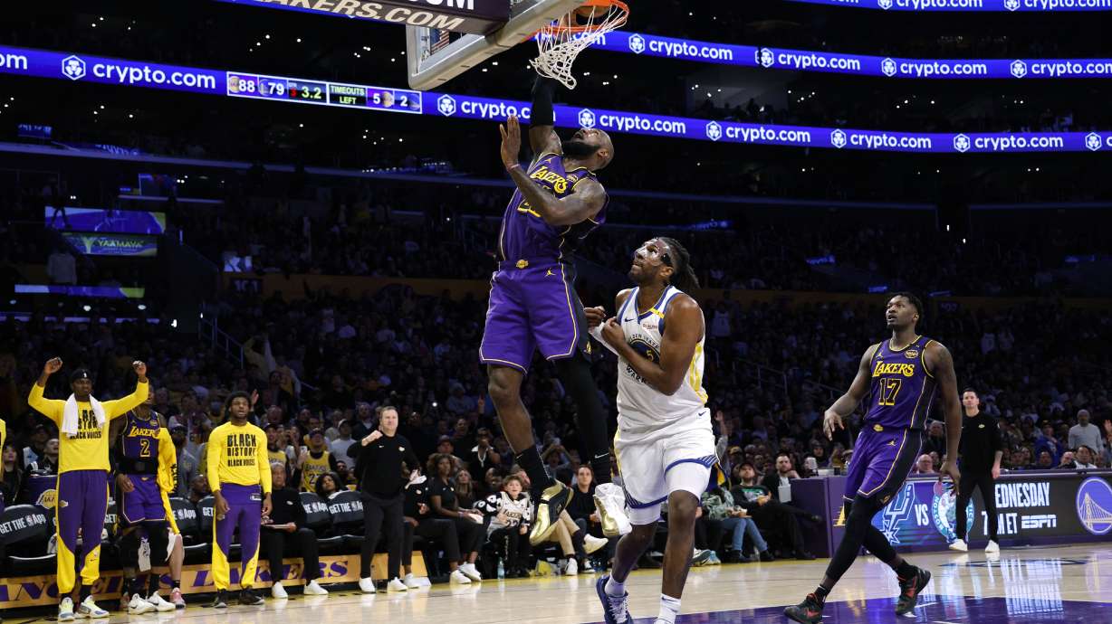 Los Angeles Lakers forward LeBron James scores a basket against Golden State Warriors forward Kevon Looney during the second half of an NBA basketball game Thursday, Feb. 6, 2025, in Los Angeles.