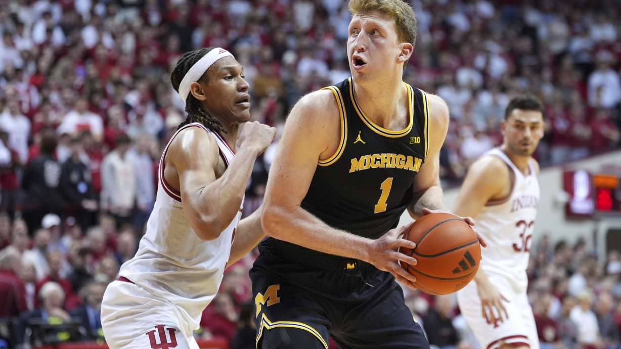 Michigan's Danny Wolf (1) spins toward the basket as Indiana's Malik Reneau defends during the first half of an NCAA college basketball game, Saturday, Feb. 8, 2025, in Bloomington, Ind.