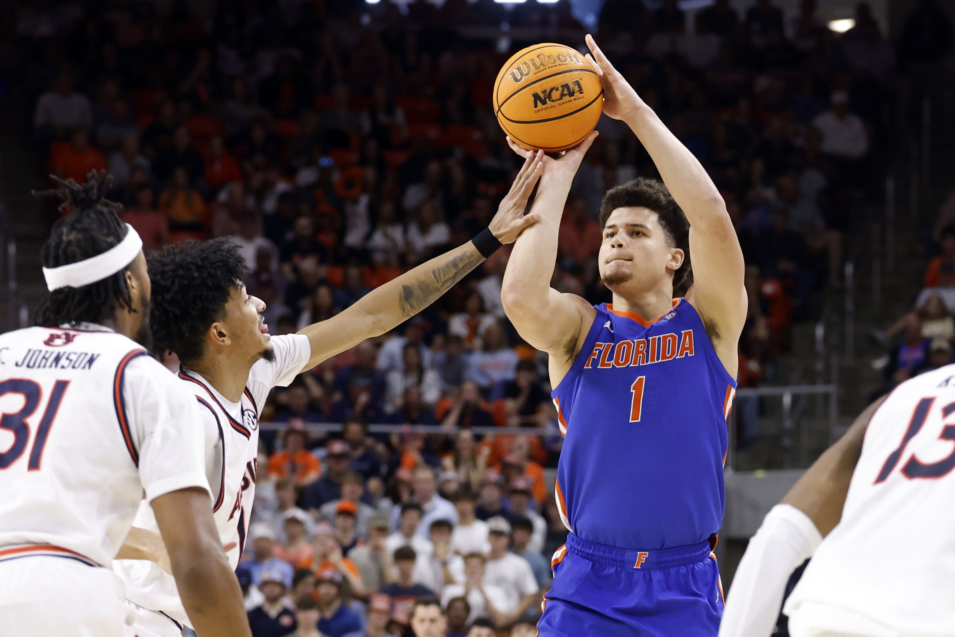 Florida guard Walter Clayton Jr. (1) is fouled by Auburn guard Chad Baker-Mazara, second from left, as he prepares to shoot a 3-point basket during the first half of an NCAA college basketball game, Saturday, Feb. 8, 2025, in Auburn, Ala.